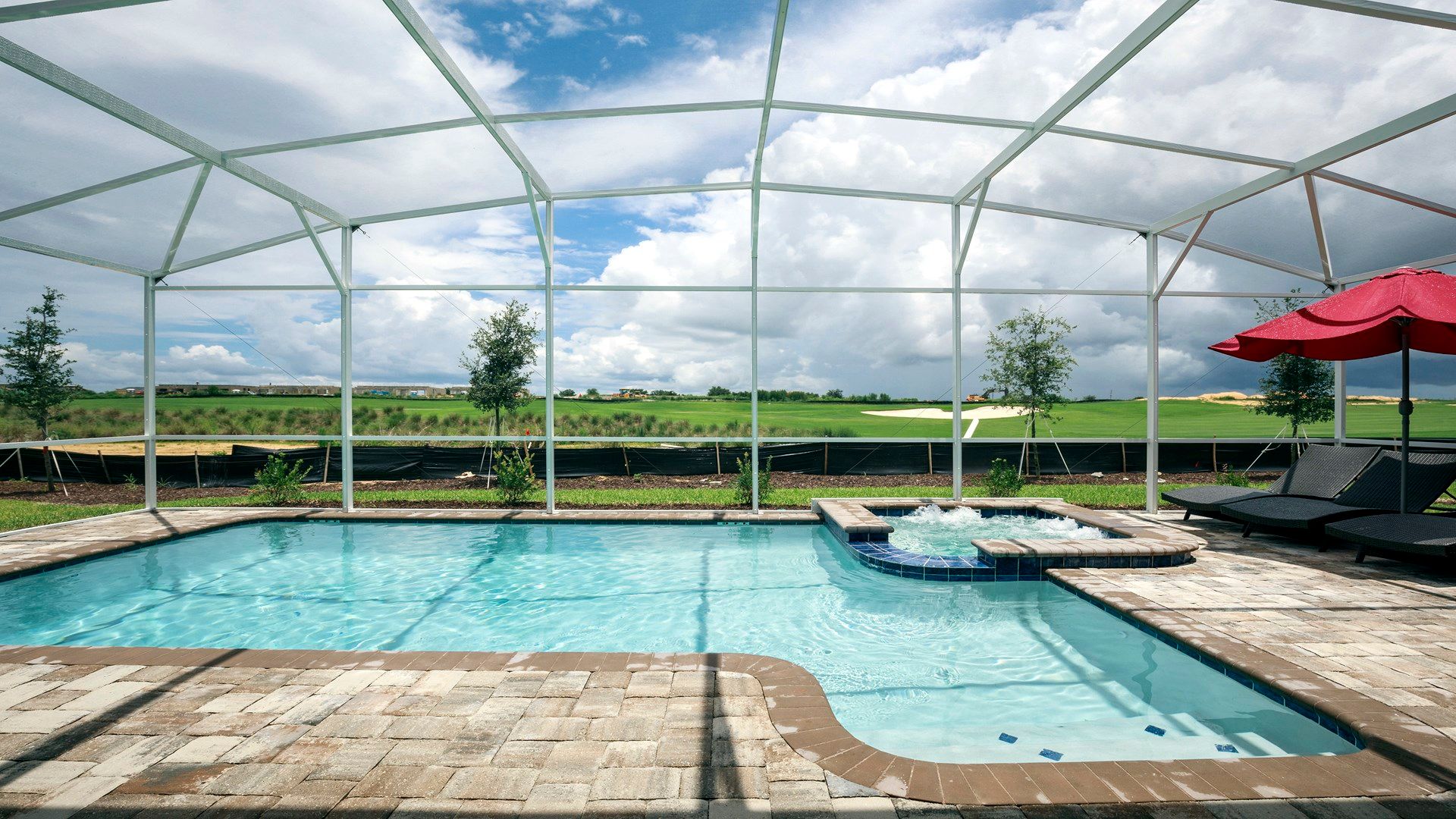 Screened pool, spa, golf views, and sunny lounging escape