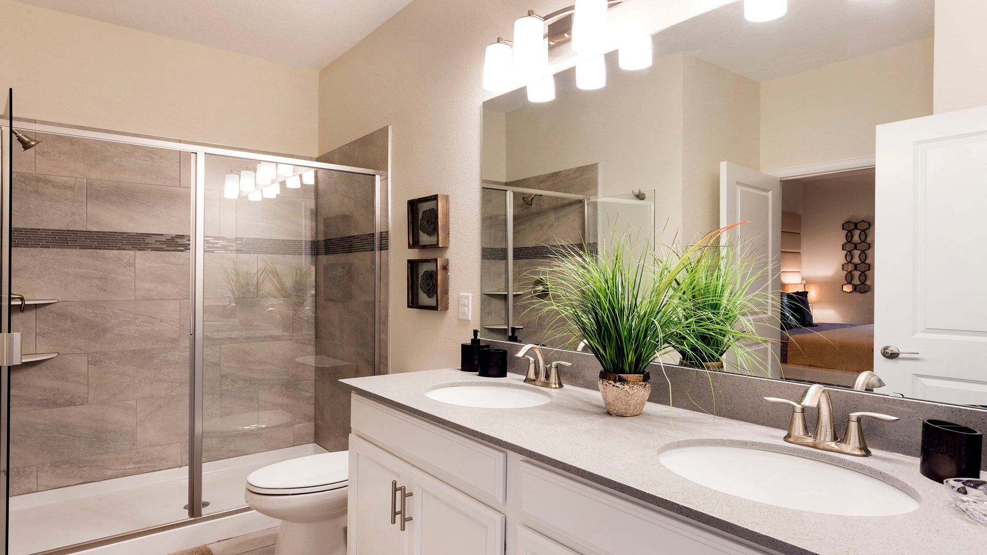 Modern bathroom with sleek shower, spacious vanity, and amenities.
