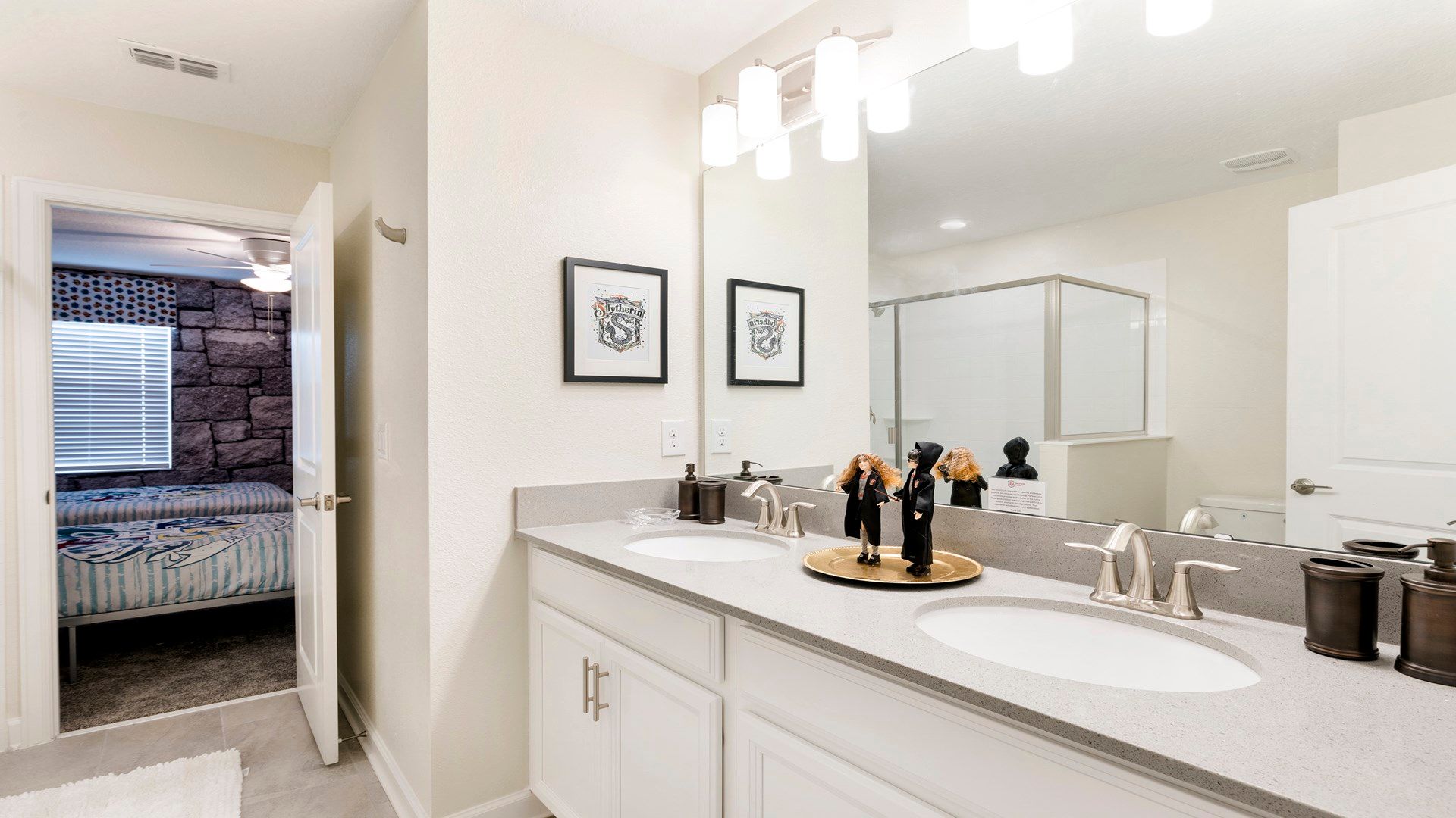 Bright bathroom with dual sinks, large mirror, and elegant decor.
