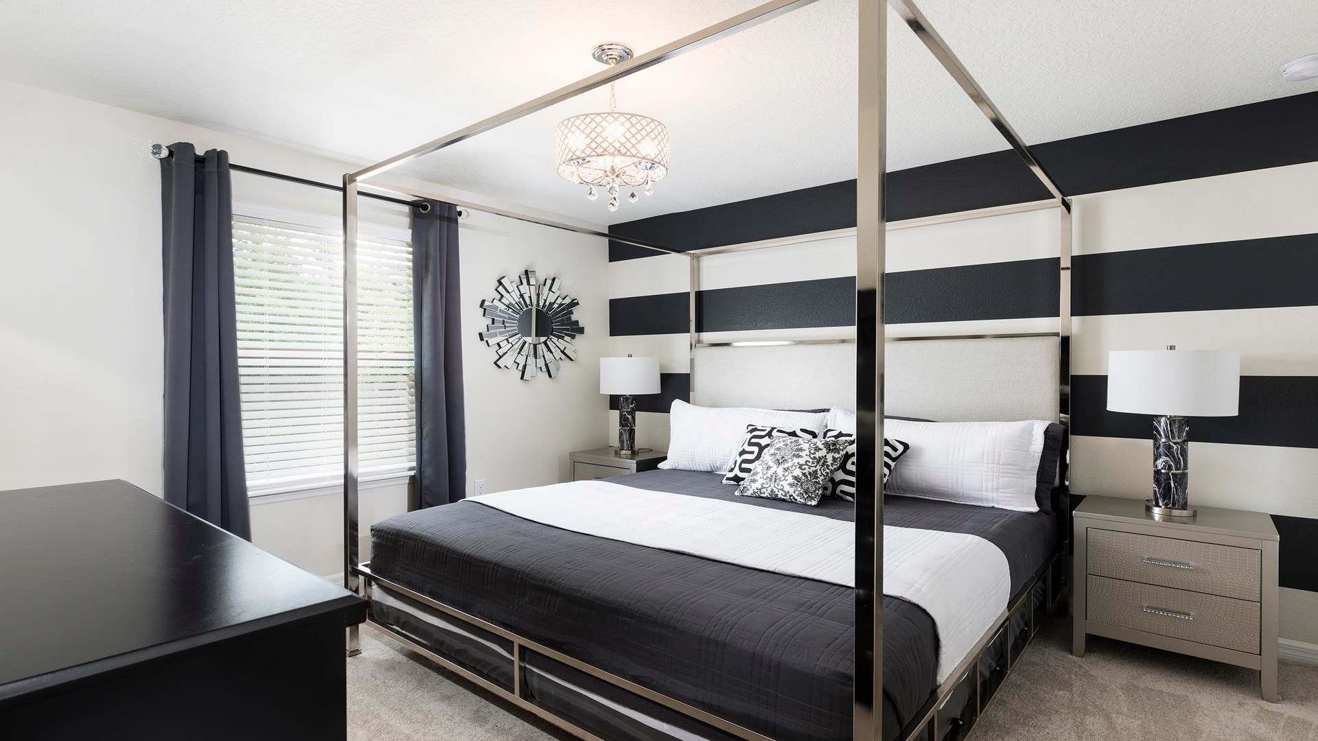 Modern chic bedroom with striped walls, canopy bed, and bold decor!