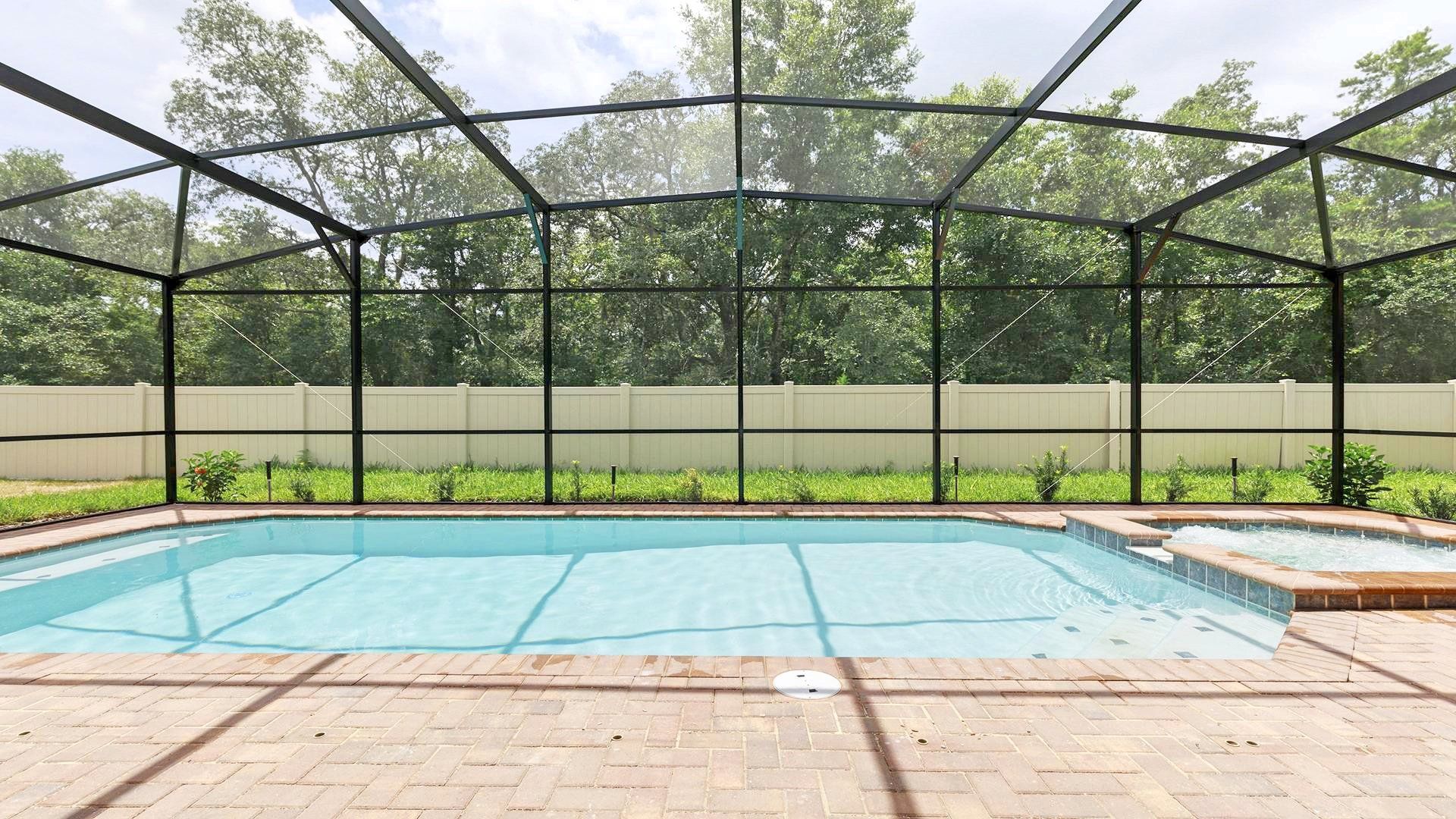 Screened-in pool and spa with serene forest views—pure relaxation!