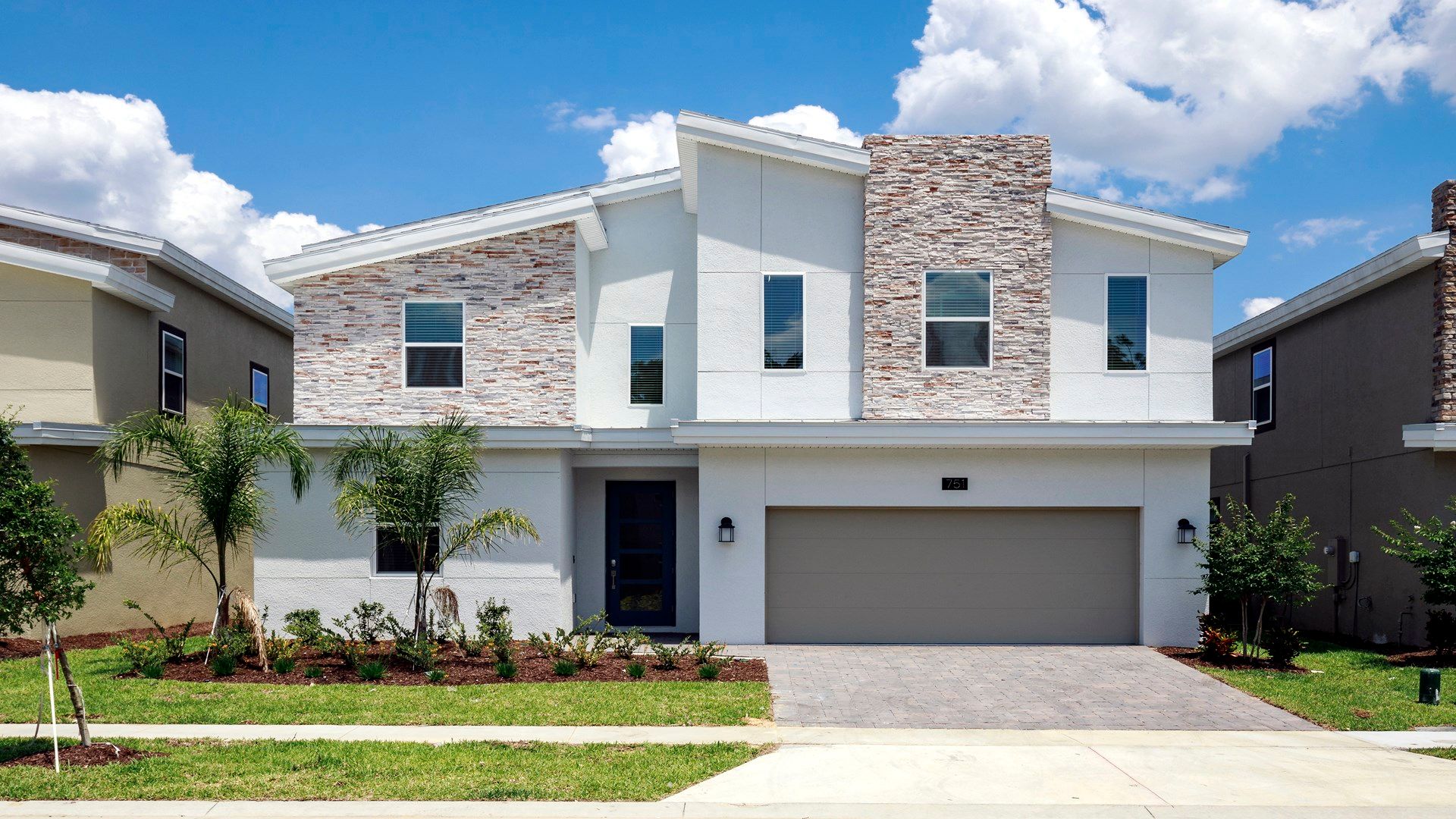 Modern vacation home with stylish design, garage, and lush landscaping