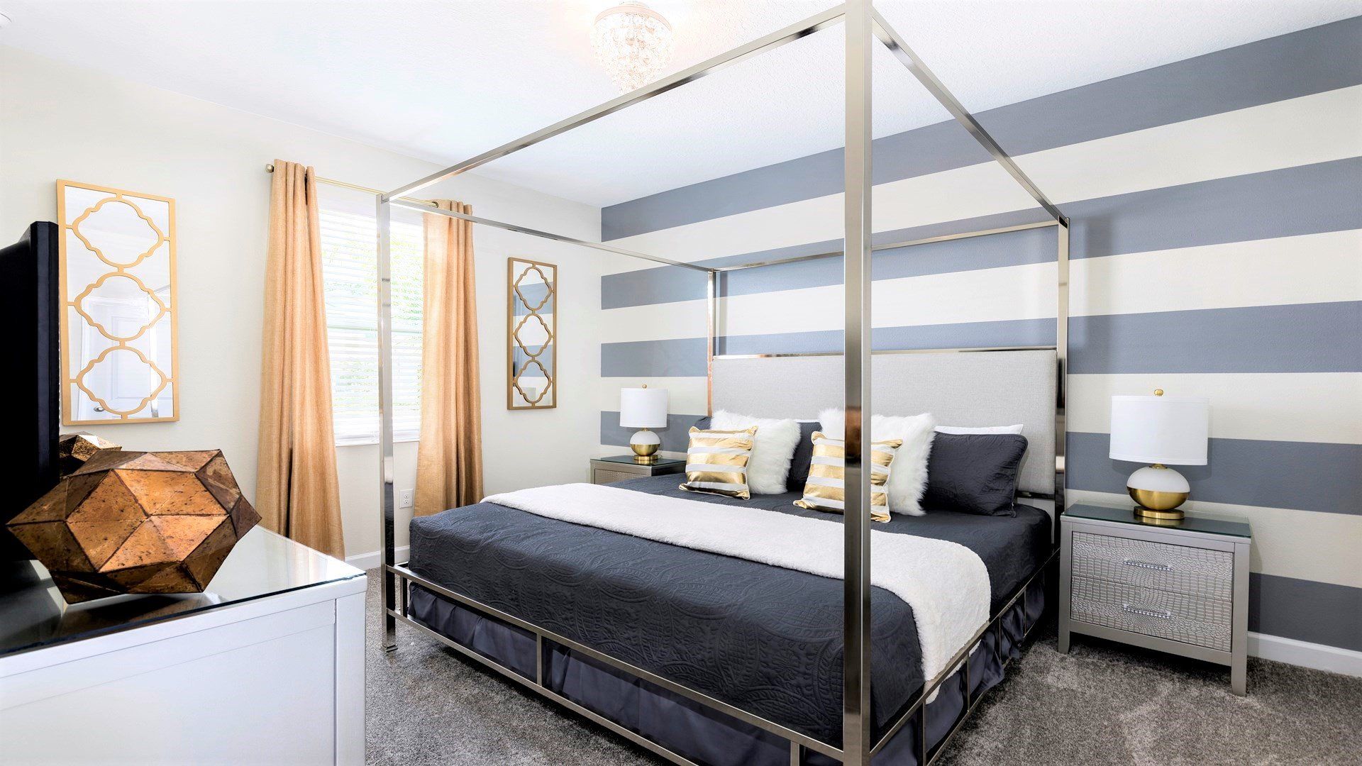 Elegant bedroom with canopy king bed, gold accents, and chic decor