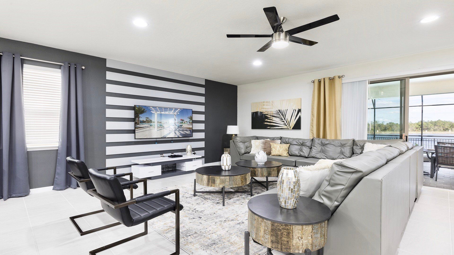 Chic modern living room with stylish decor, cozy seating, and a view to the pool and lake beyond.