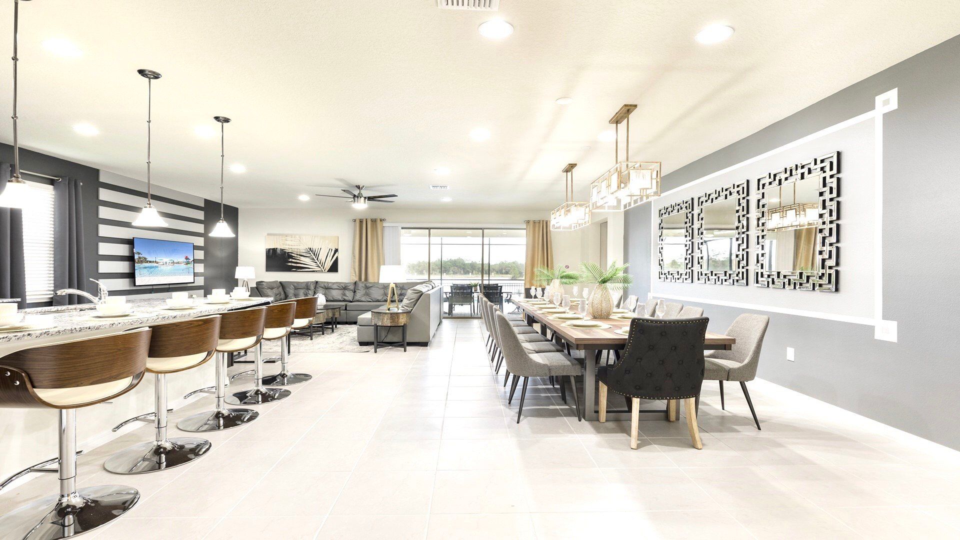 Open-concept living area with elegant dining, stylish bar seating, and a stunning view of the lake and pool.