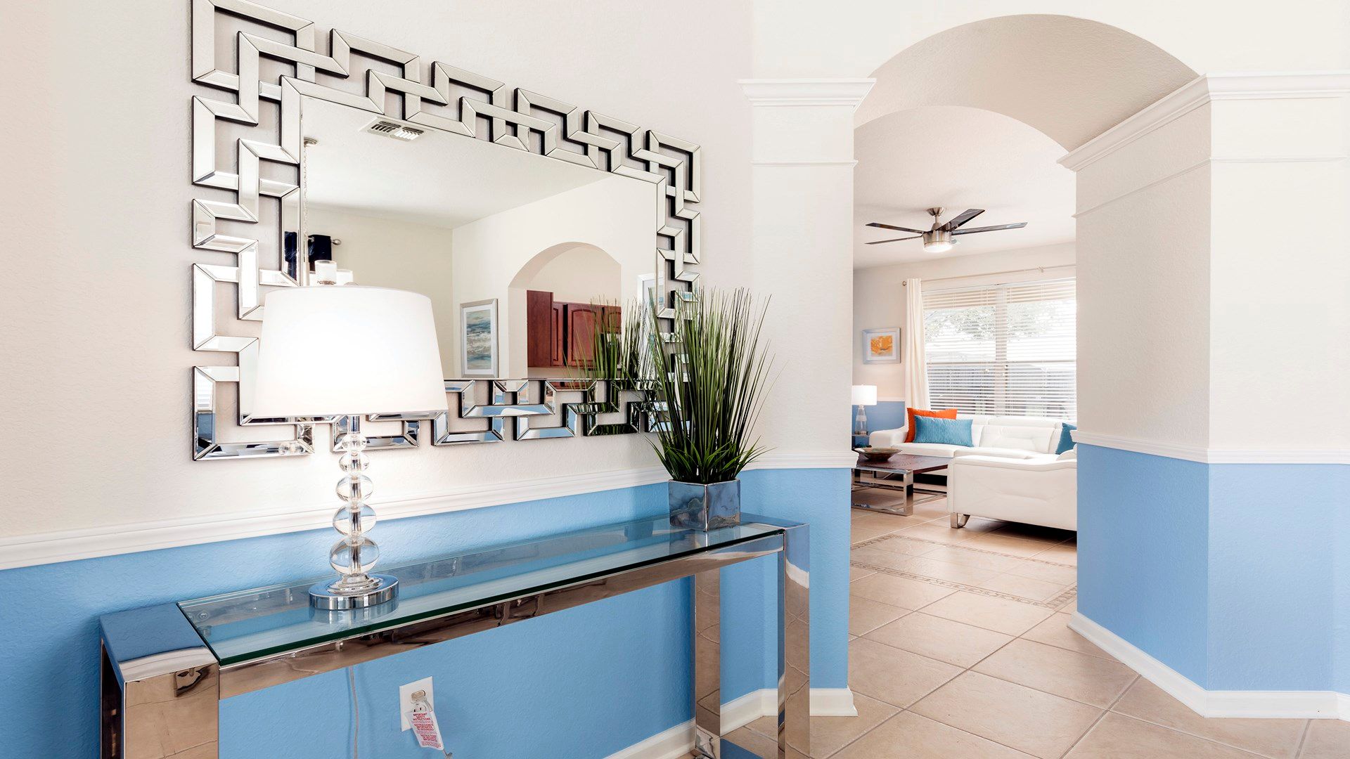 Stylish entryway with a chic mirror, modern decor, and a glimpse of the cozy living room!