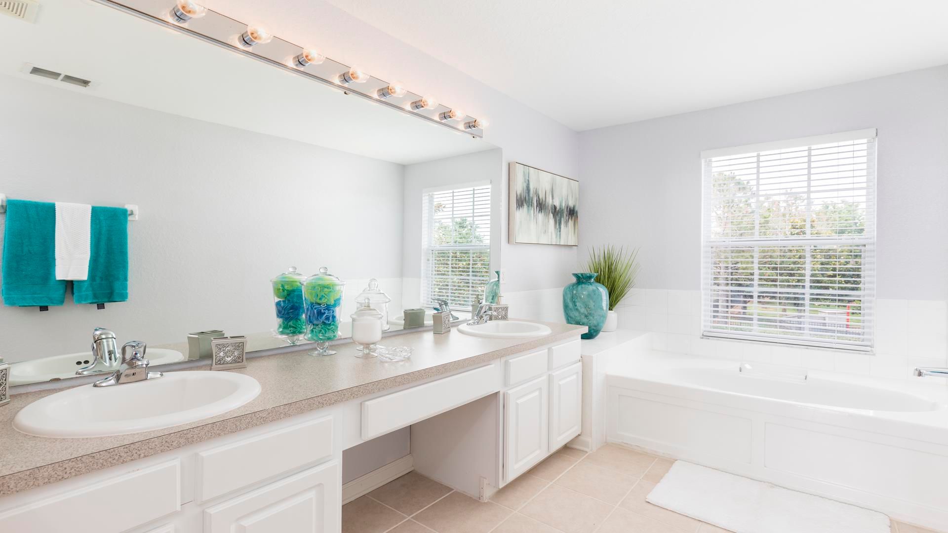 Bright and spacious bathroom with double sinks, a soaking tub, and modern decor!