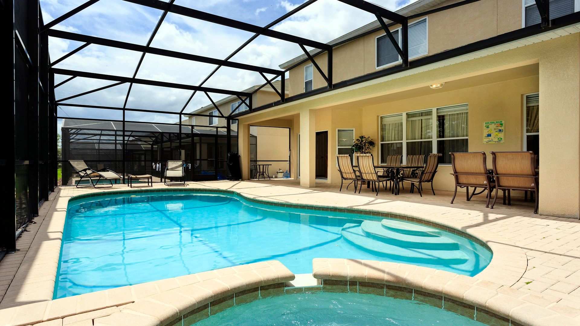 Private screened-in pool and spa with lounge chairs, outdoor dining, and sunny vibes!