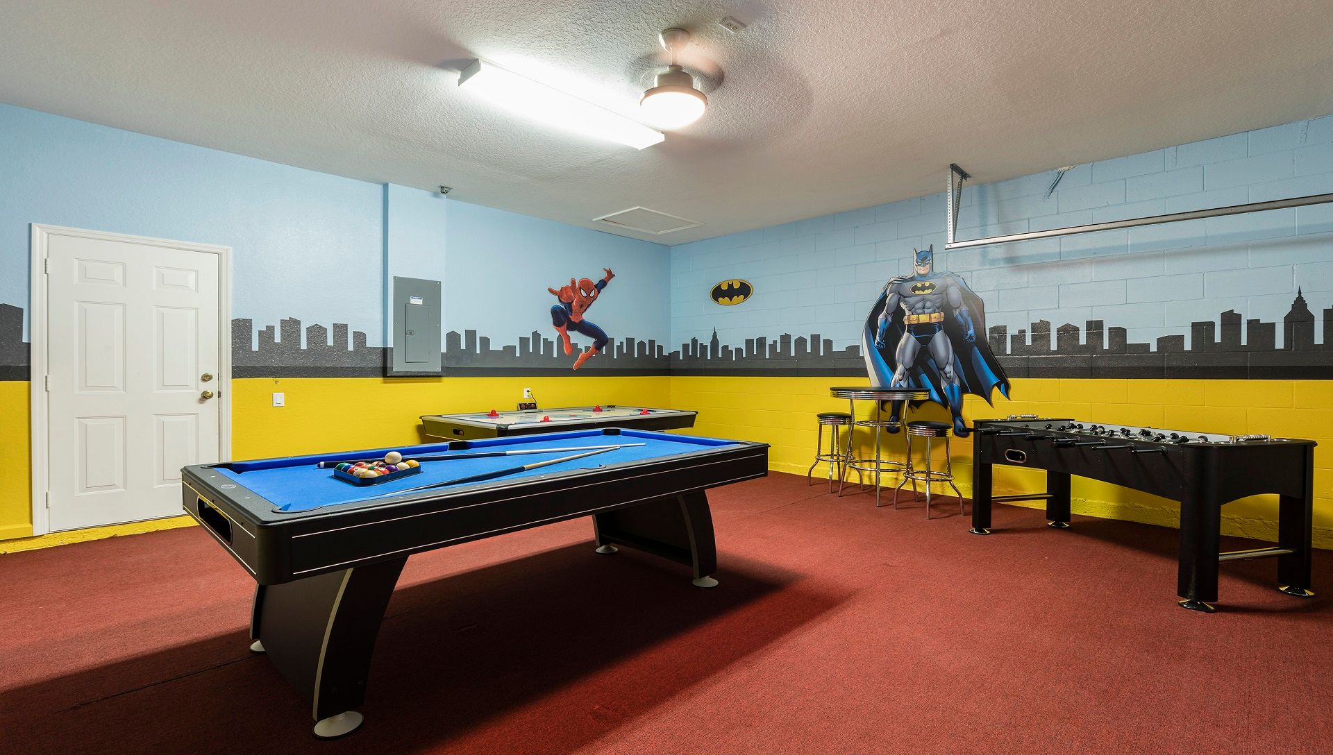 Action-packed superhero game room with pool, air hockey, foosball, and city decor.