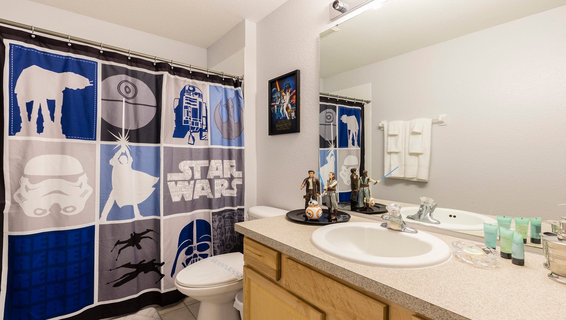 Star Wars-themed bathroom with fun decor, character figurines, and a bold shower curtain.