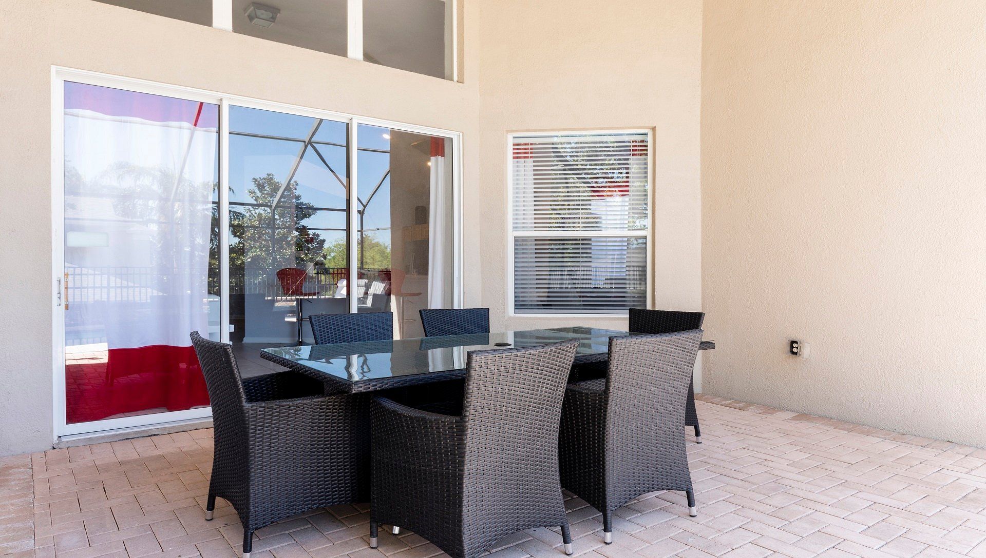 Stylish covered patio with cozy wicker seating, perfect for outdoor dining and relaxation.