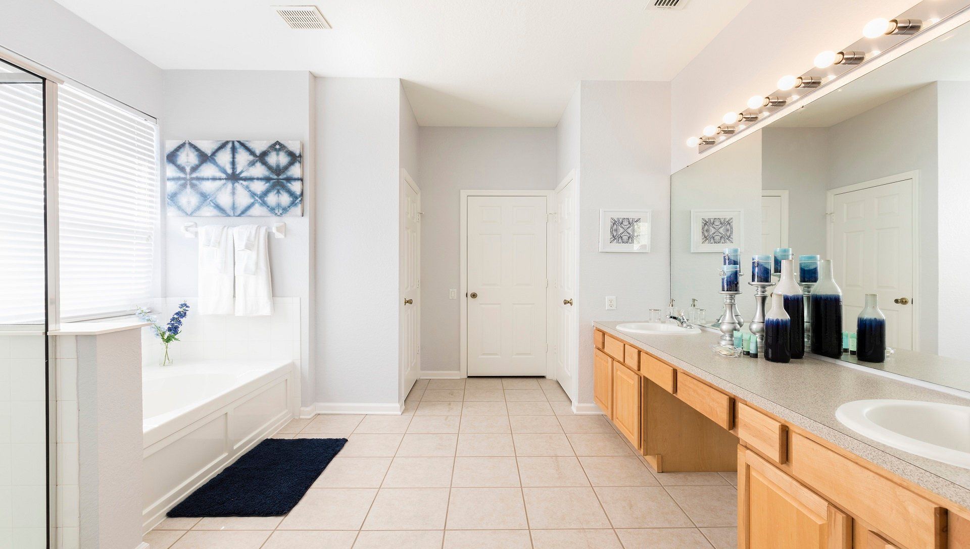 Spacious, elegant bathroom with a large vanity, soaking tub, and modern decor.