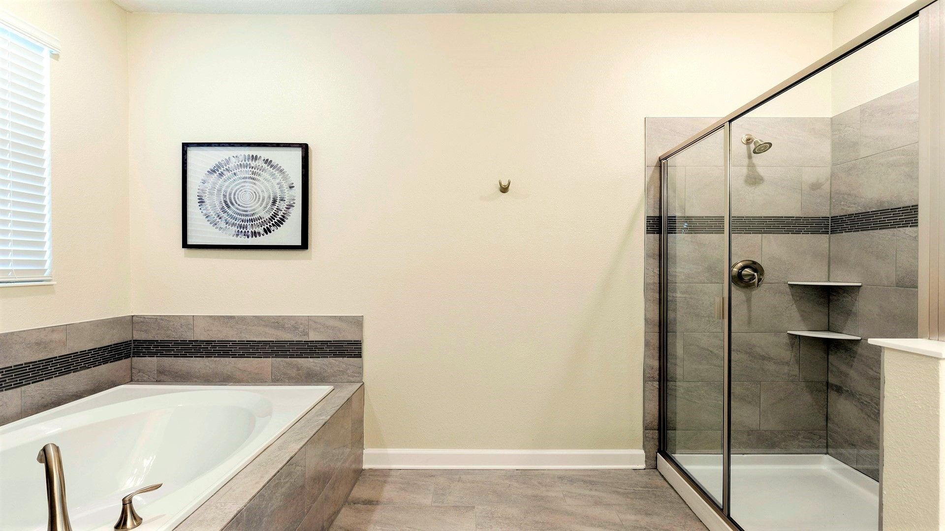 Modern bathroom with tub, glass shower, and sleek tile accents.