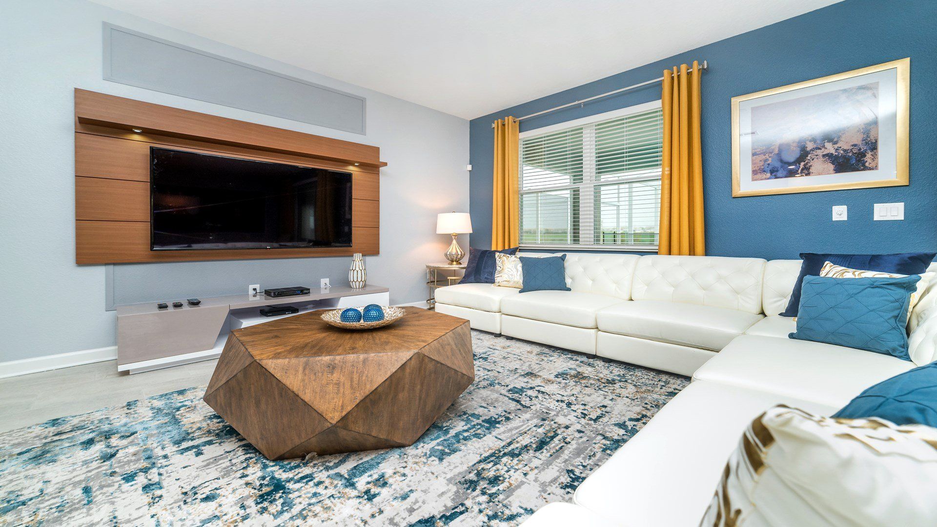 Chic living area with plush seating, vibrant accents, and a large TV