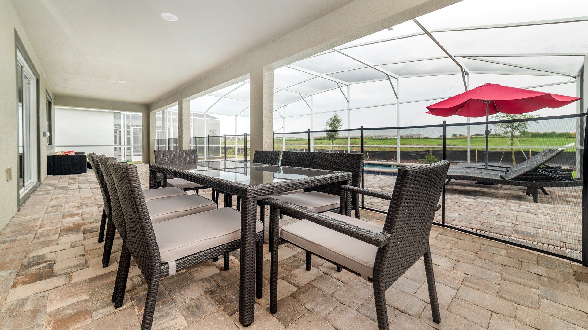 Outdoor dining table and loungers with views of the pool and lake