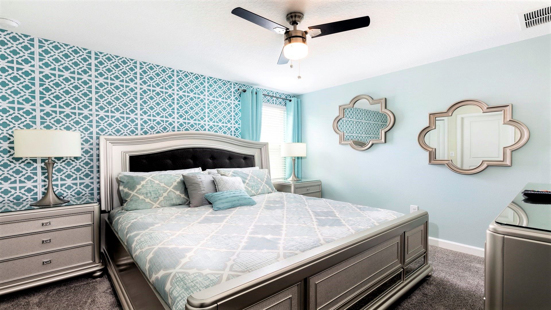 Stylish bedroom with king bed, chic patterned wall, and soft hues