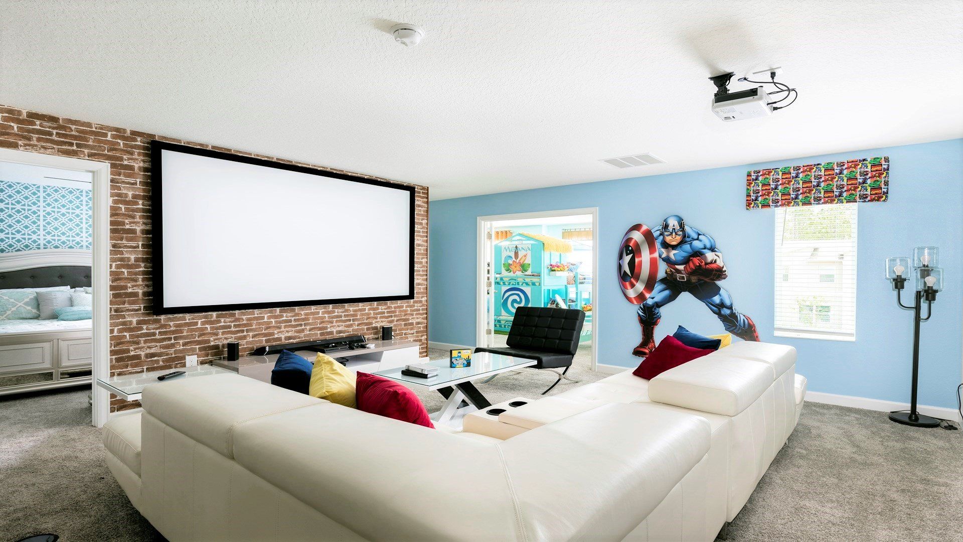 Cozy home theater with a large screen, projector, and superhero flair