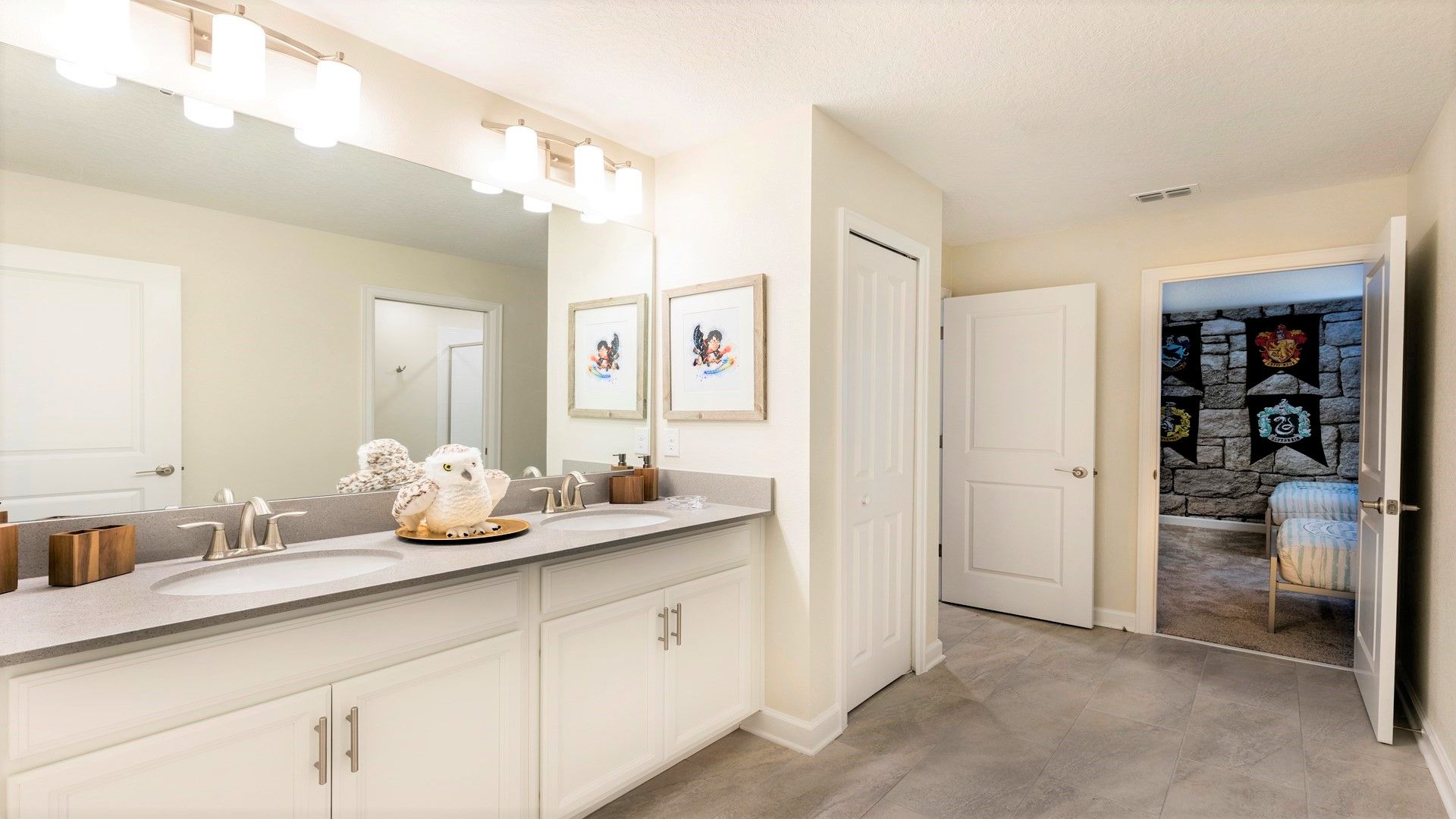 Spacious bathroom with double sinks, elegant lighting, and decor