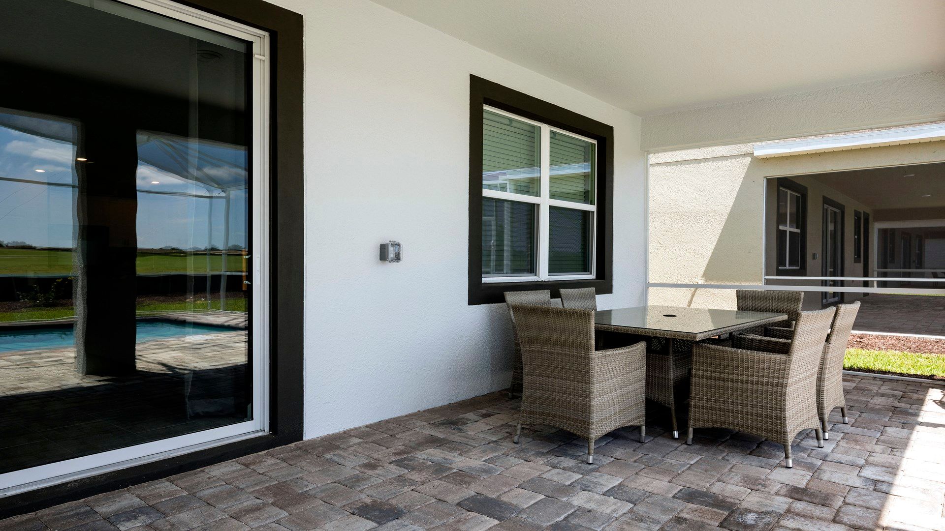 Cozy outdoor dining area with wicker seating and poolside views
