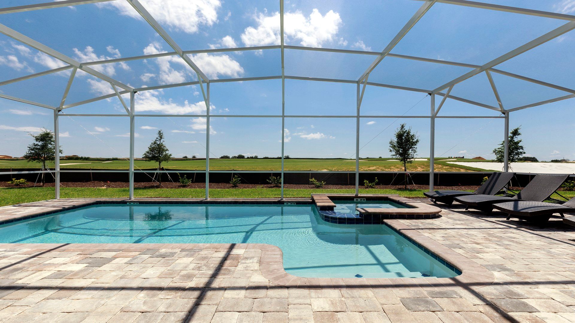 Spacious pool area with loungers, hot tub, and panoramic views