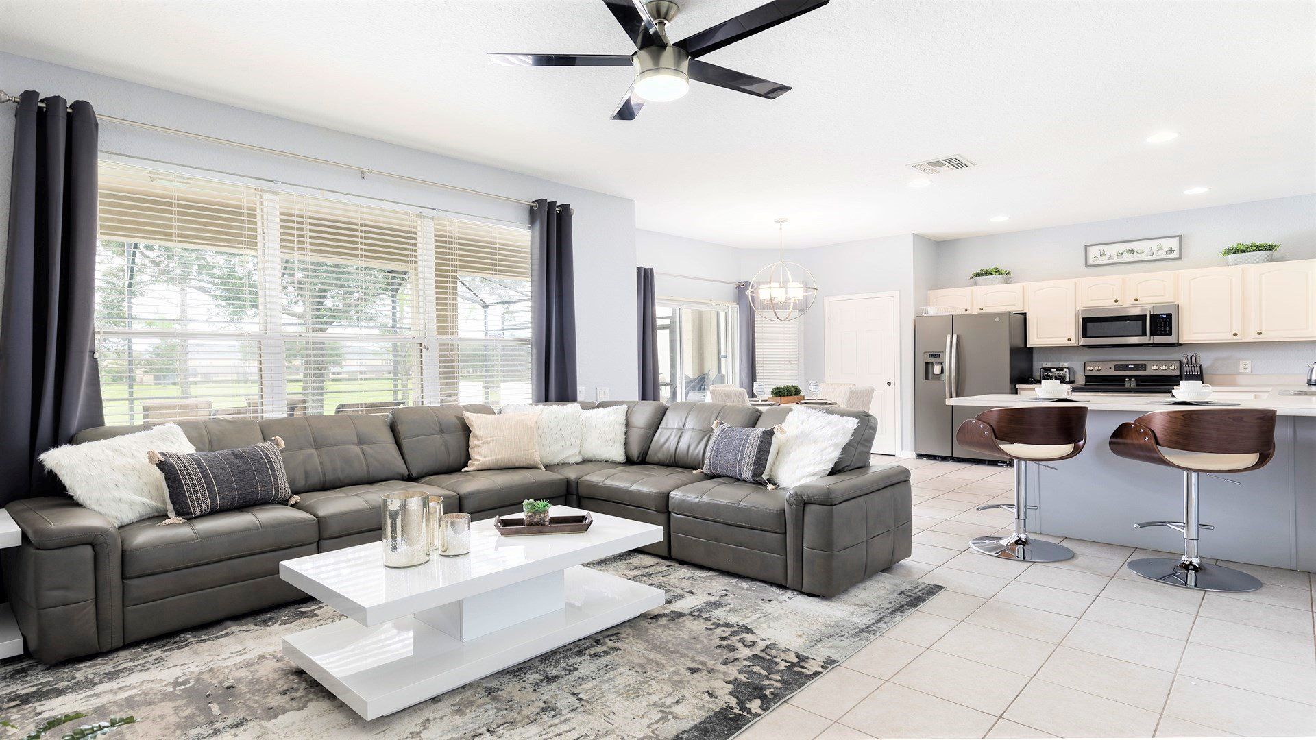 Bright and modern open-concept living space with a cozy sectional and sleek kitchen!