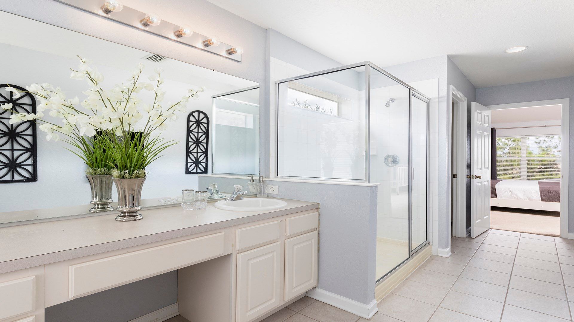 Spacious and bright ensuite bathroom with a glass shower and elegant vanity area!