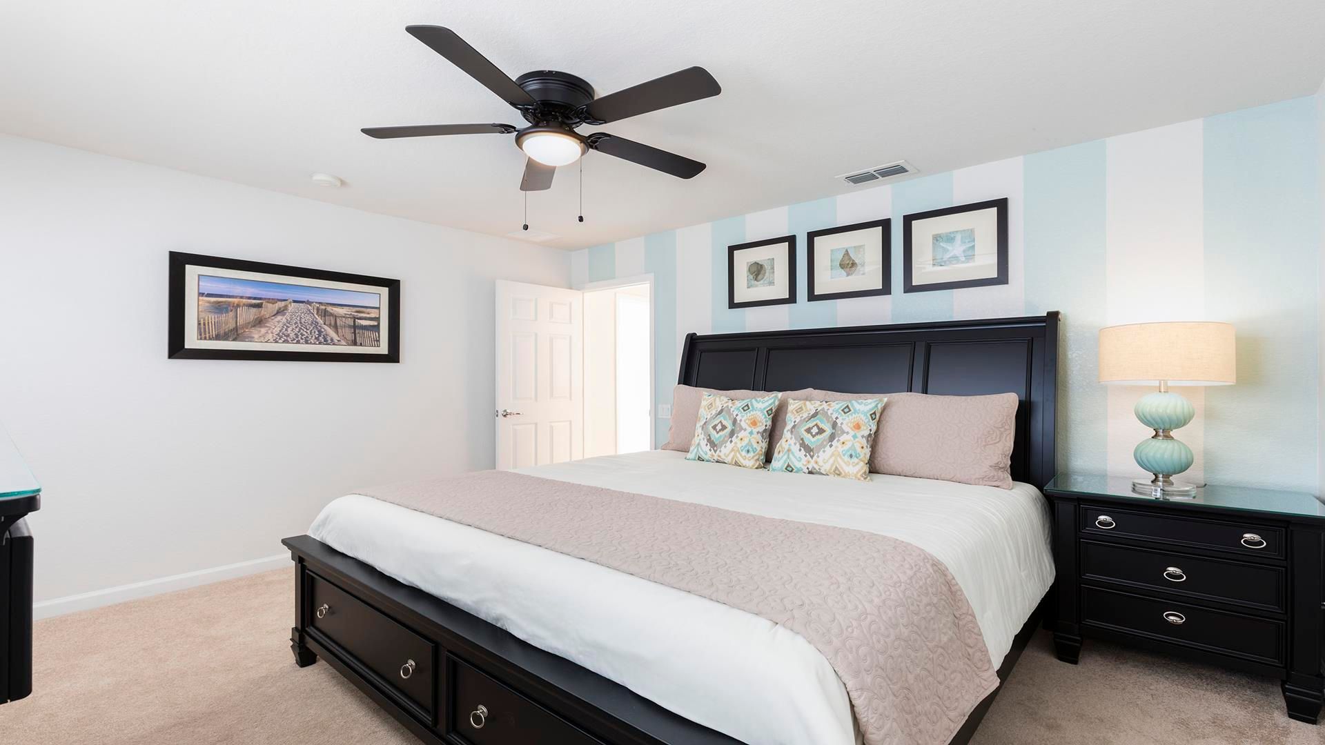 Relaxing master bedroom with king bed, tasteful decor, and soothing beach theme.
