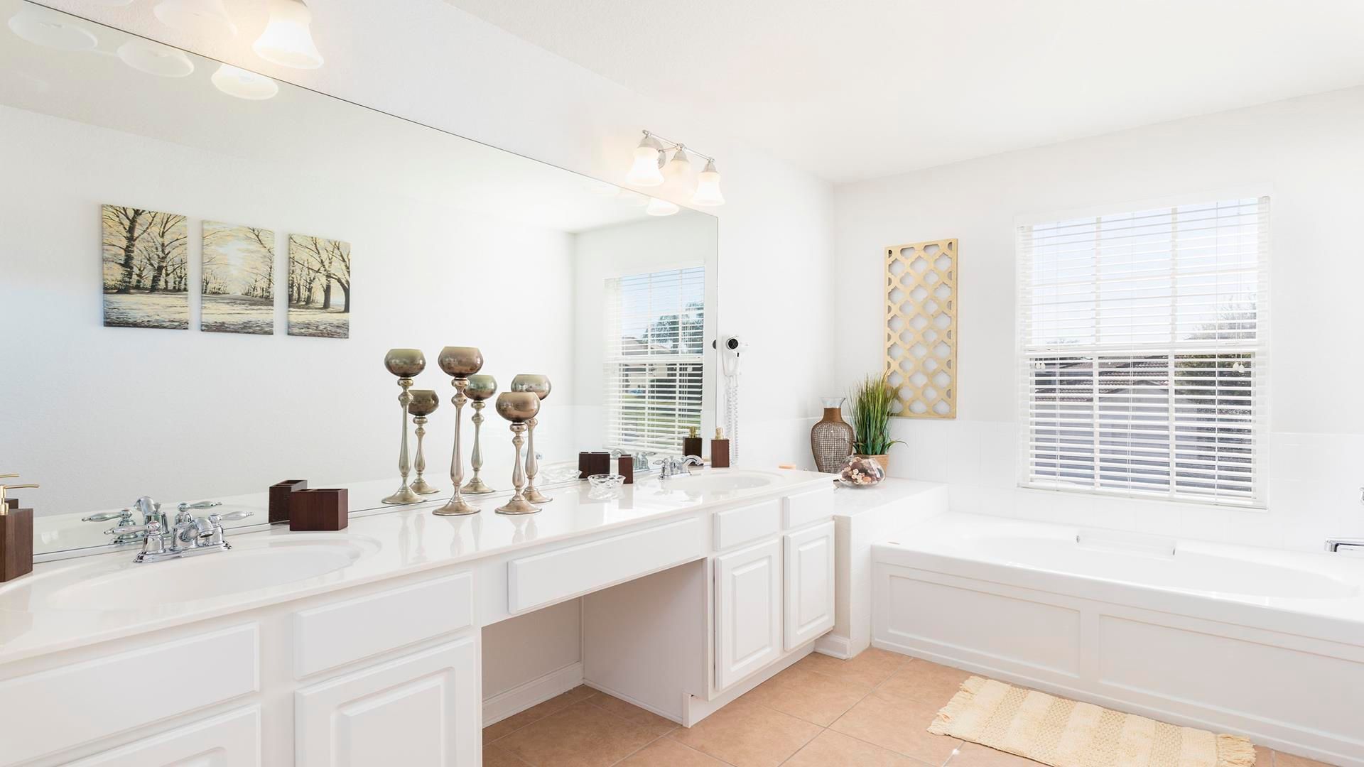 Elegant bathroom with double vanity, soaking tub, and serene decor accents.