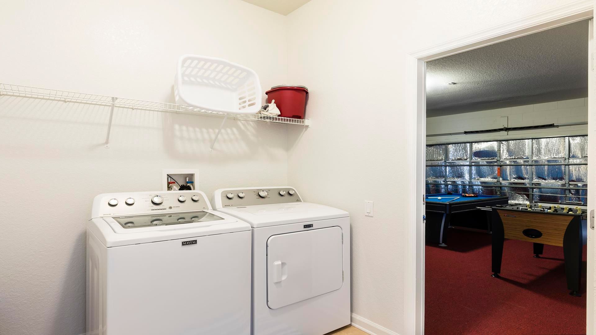 Convenient laundry area with modern appliances, connected to a fun game room.