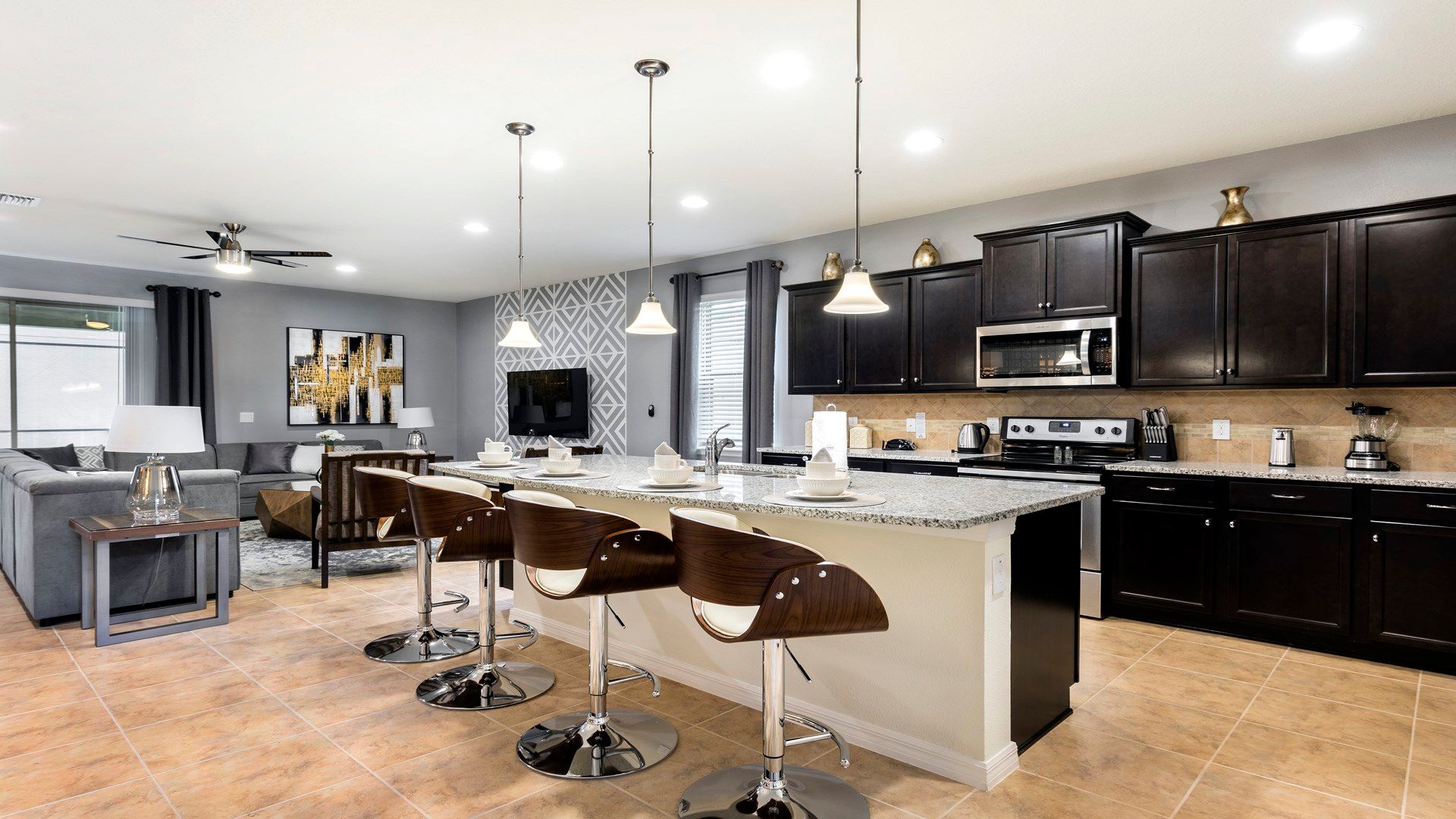 Modern kitchen with granite island, sleek appliances, and open flow to living area.