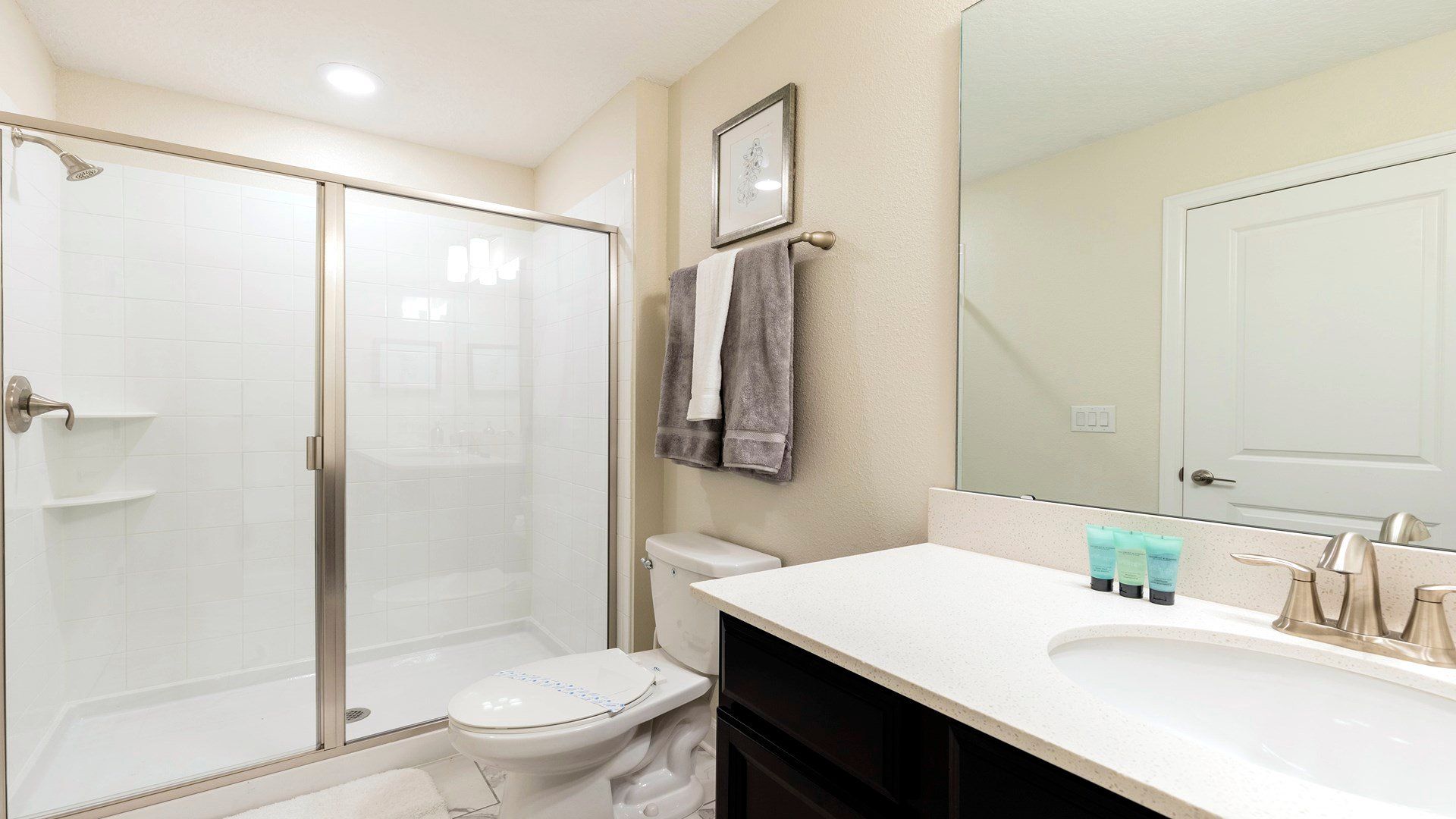 Spacious spa-like bathroom with marble finishes, soaking tub, and glass shower.