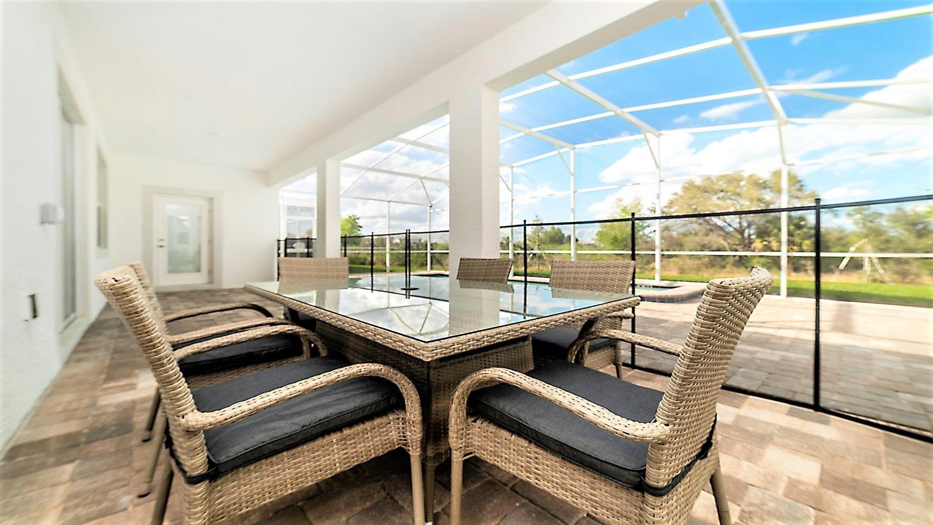 Spacious outdoor patio with pool views, cozy seating, and serene surroundings.