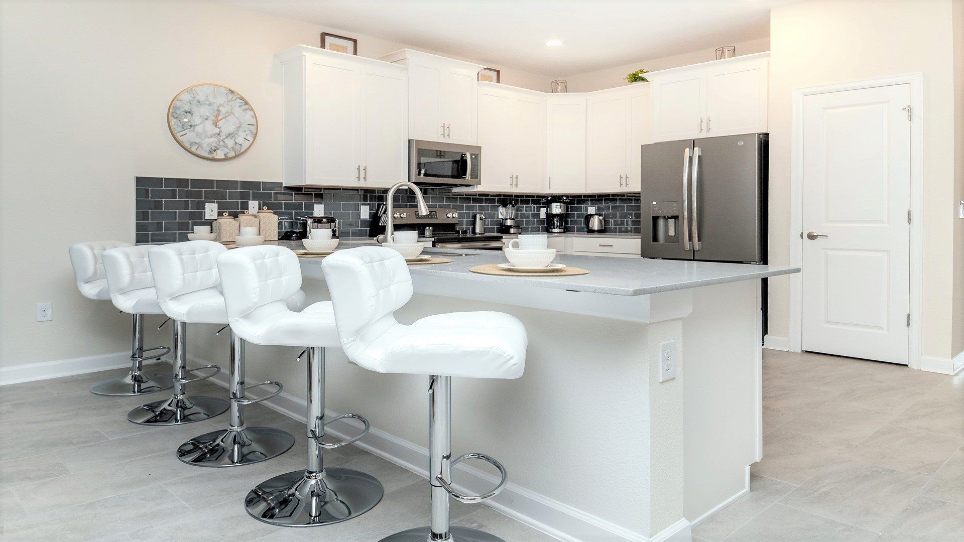 Modern kitchen with sleek bar seating, stainless appliances & style!
