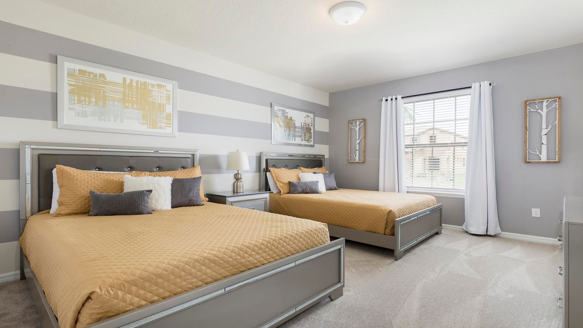 Bright and modern bedroom with double beds, striped walls, and chic decor!