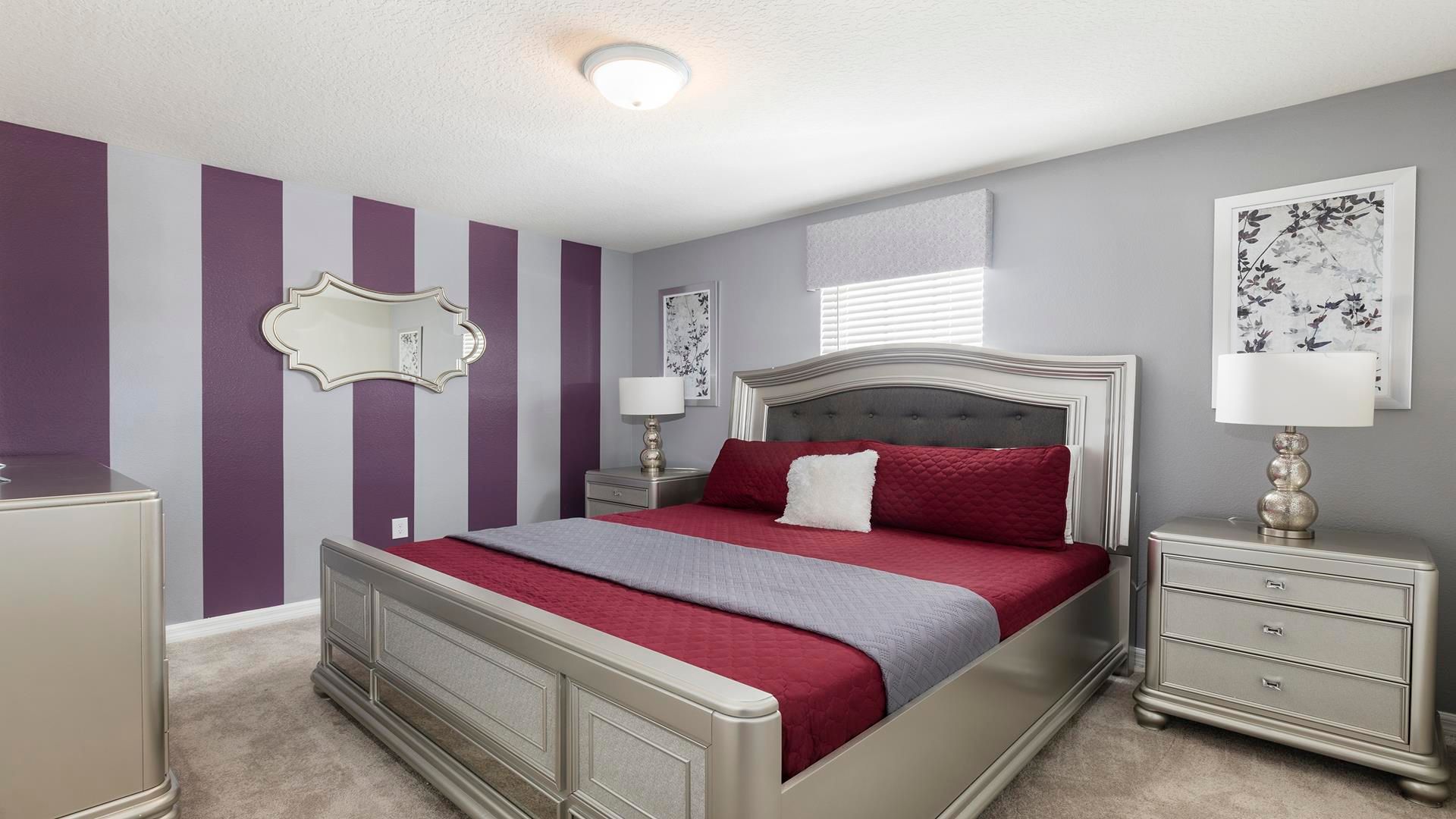 Elegant bedroom with bold purple stripes, luxe decor, and king bed!