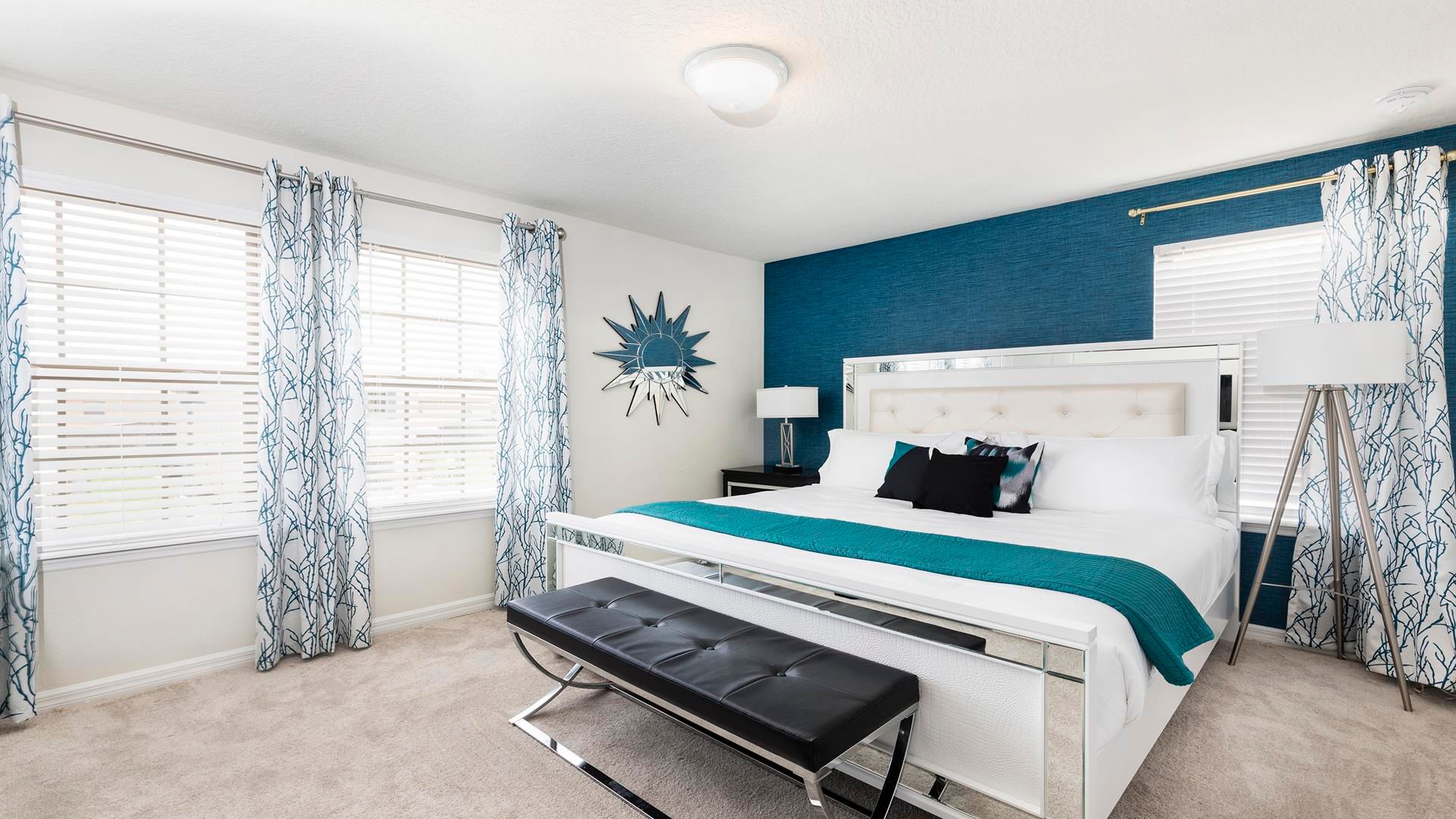 Elegant master bedroom with king bed, bold accents, and natural light!