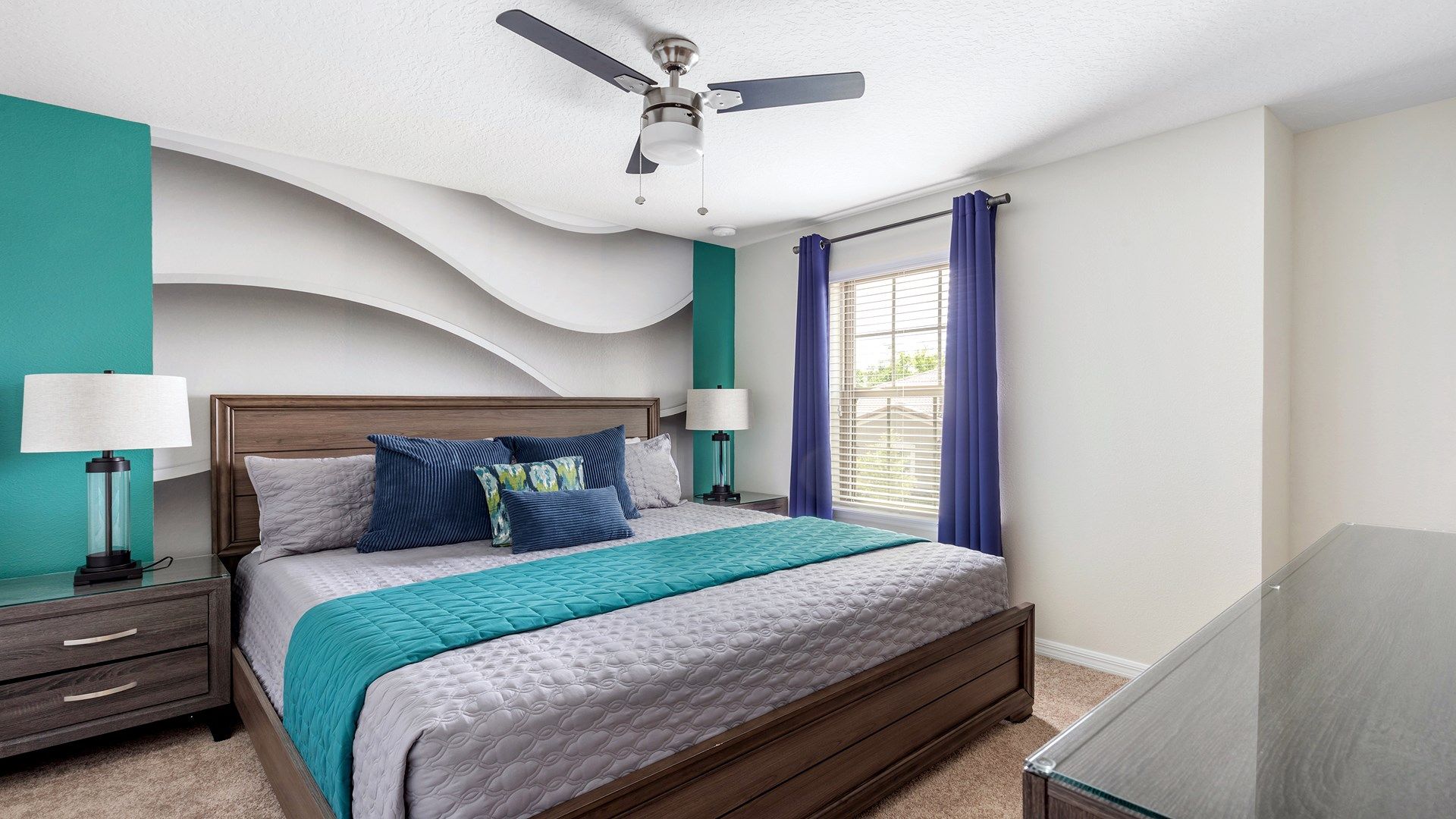 Stylish king bedroom with bold accents, wave design wall, and natural light.