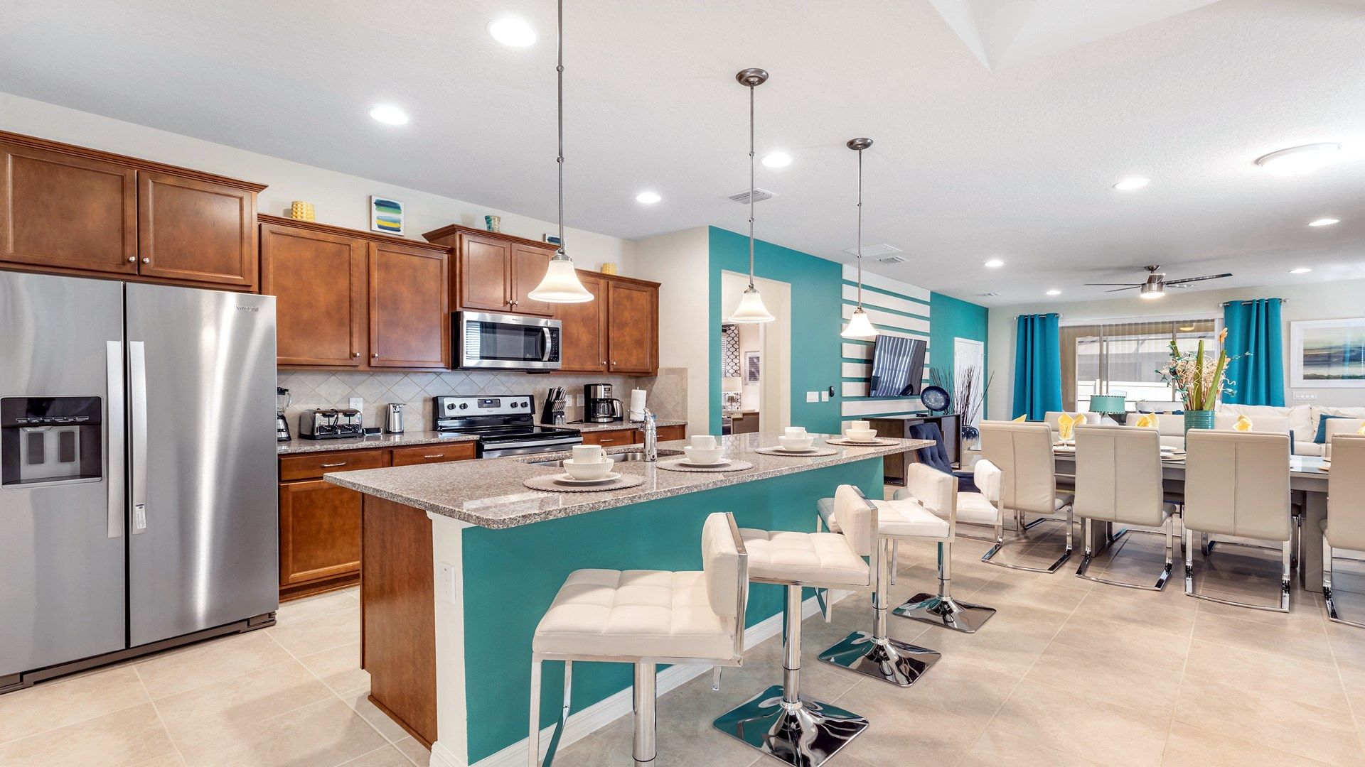 Fully equipped kitchen with island seating, stainless appliances, and open layout.