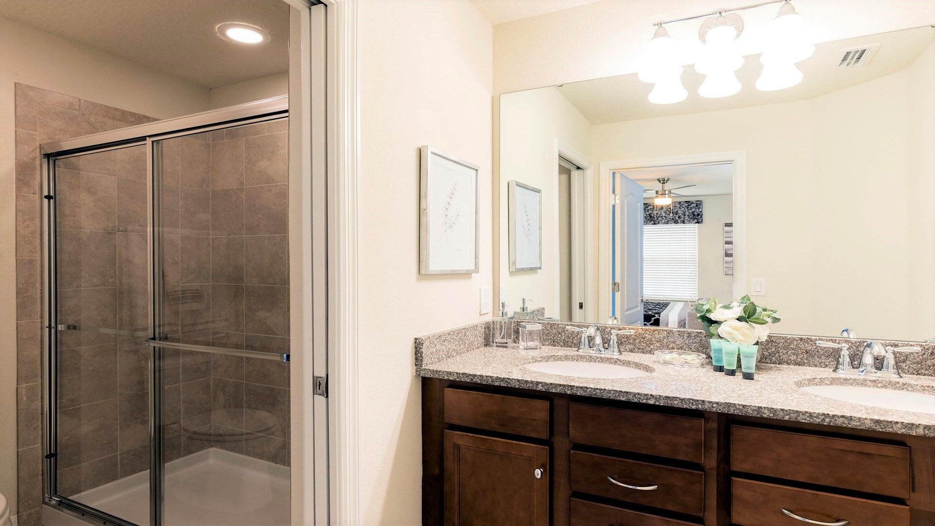 Bright, modern bathroom with double vanity and sleek glass-enclosed shower.