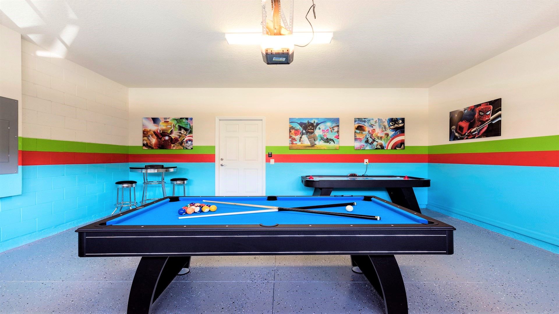 Hero-themed game room with pool, air hockey, and colorful, playful decor.