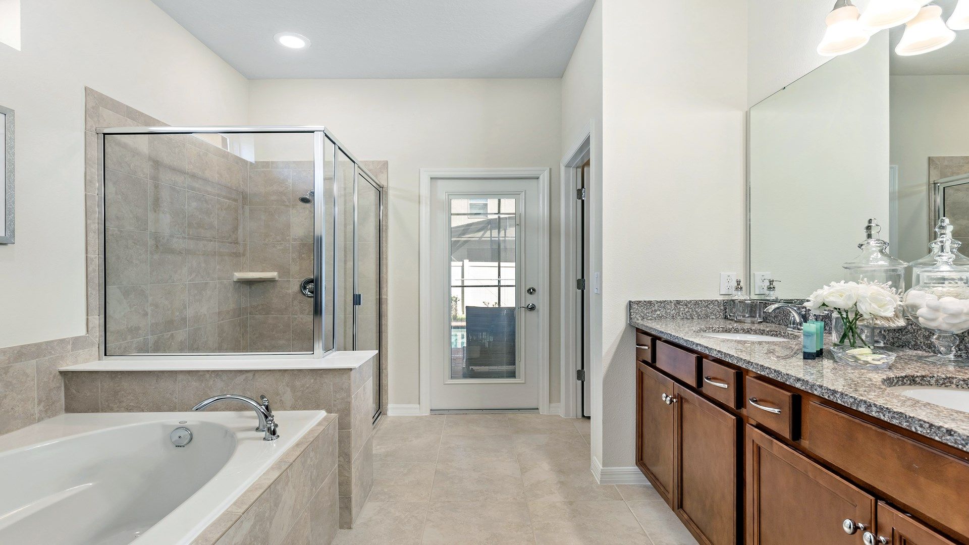 Luxurious master bath with soaking tub, glass shower, and patio access.
