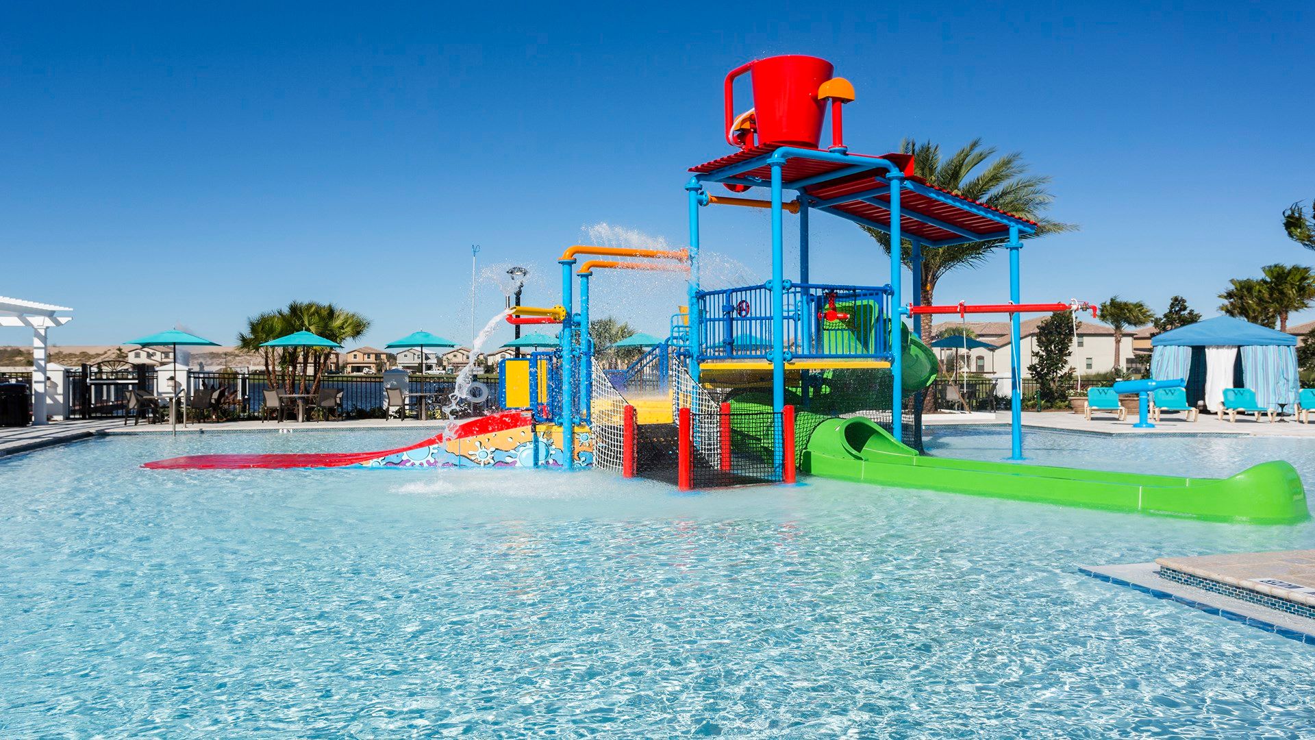 Resort-style splash zone with slides, water fun, and relaxing cabanas nearby.