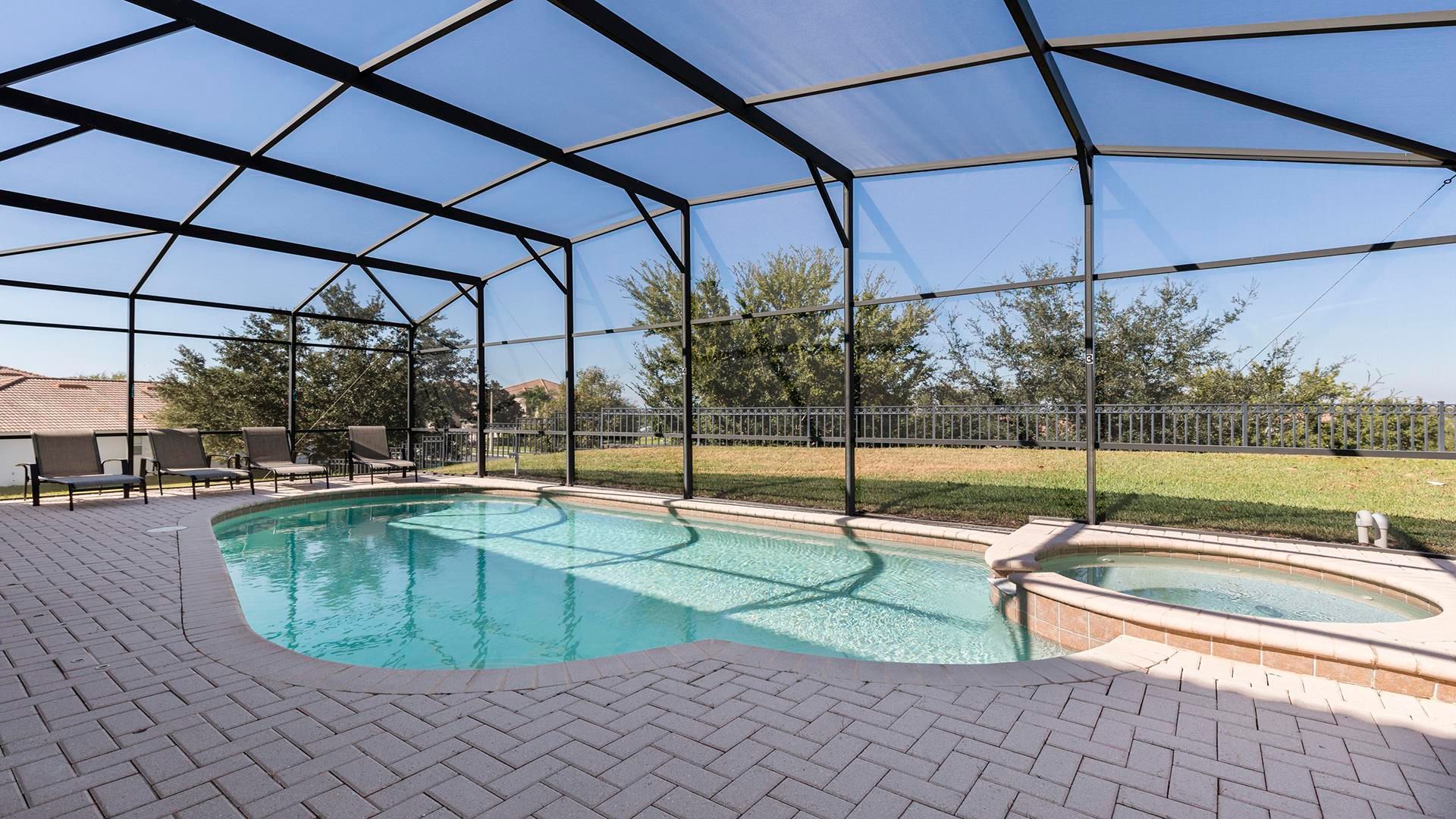 Private screened pool with spa and lounge chairs, perfect for relaxing in the sun.