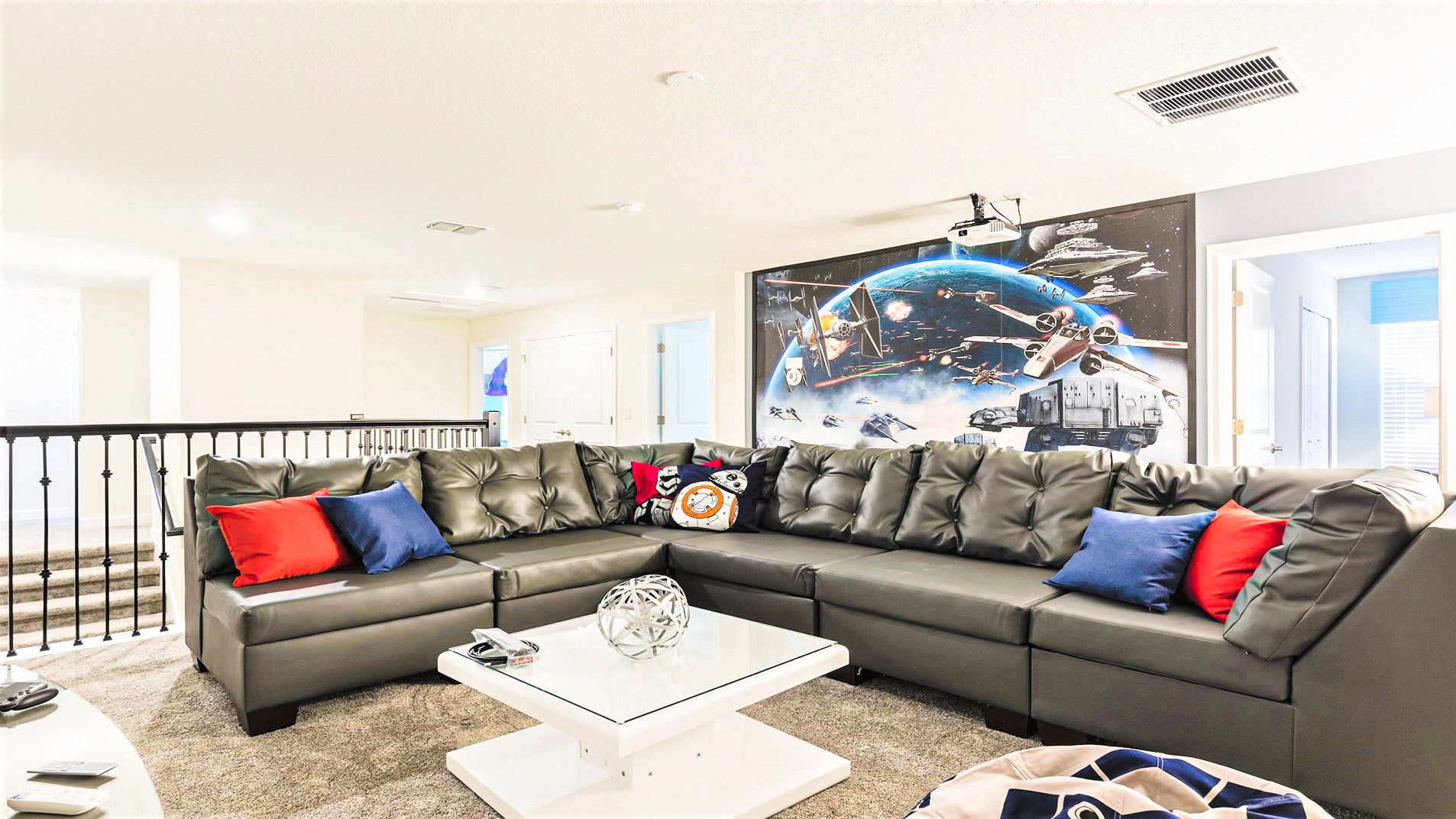 Galactic-themed lounge with cozy sectional, movie projector, and Star Wars decor—perfect for movie nights!