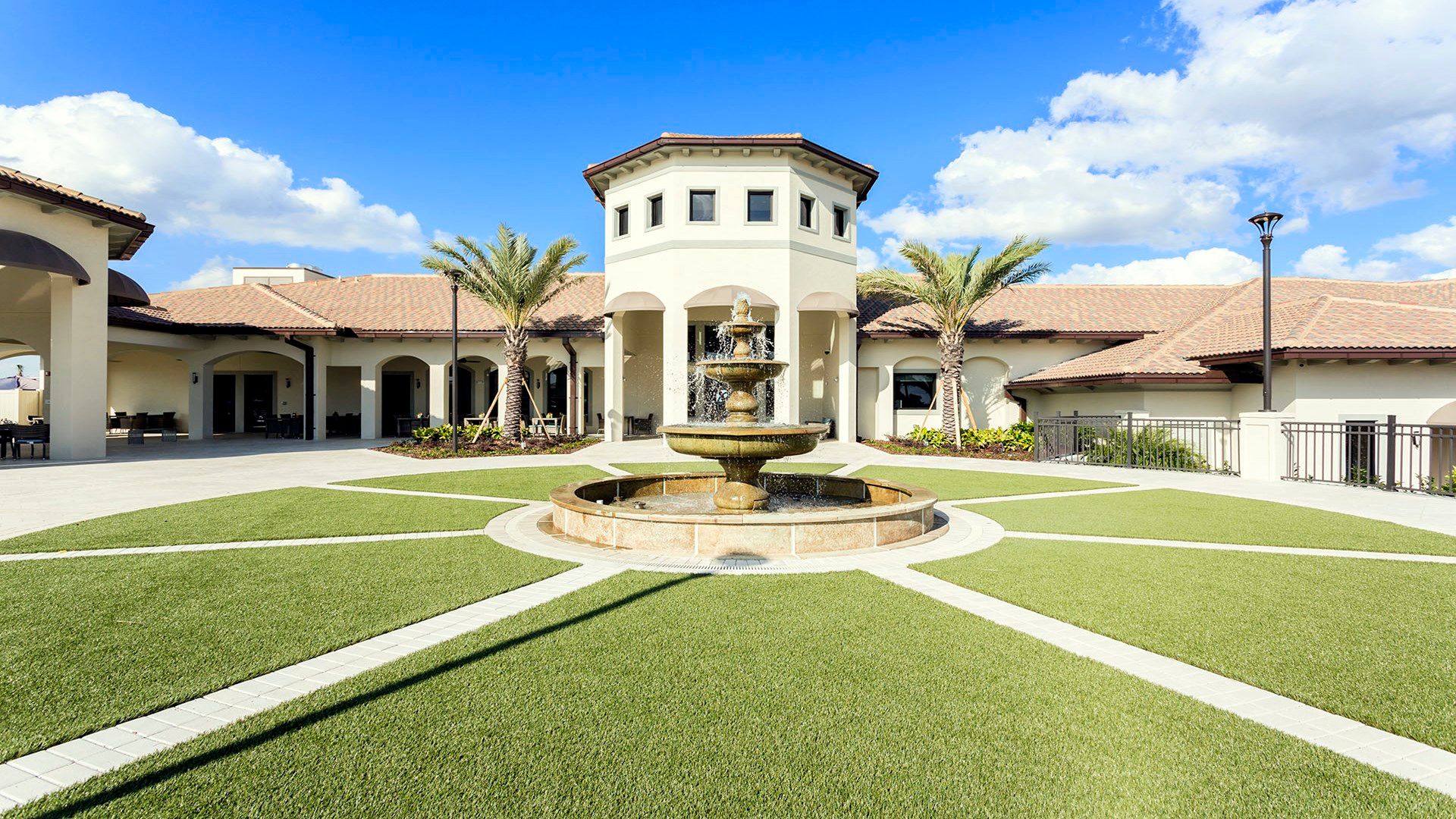 Elegant courtyard with a grand fountain and lush landscaping, perfect for a relaxing escape.