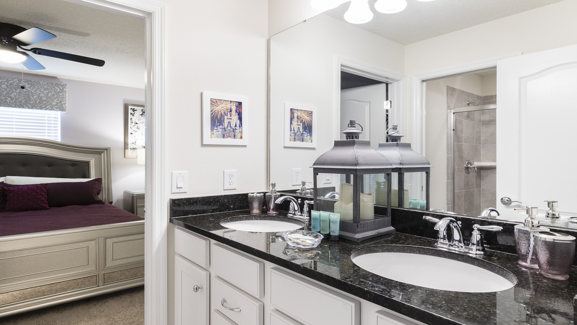 Elegant bathroom with double sinks, granite counters, stylish decor, and an adjoining bedroom view.