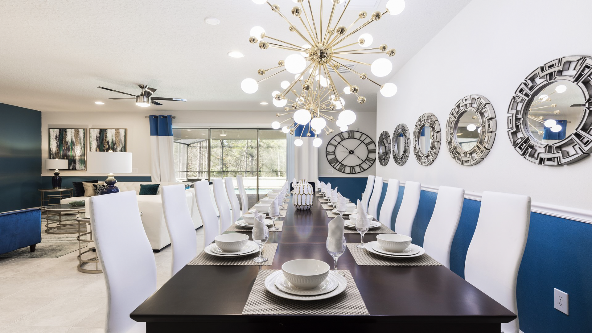 Elegant dining area with seating for 14, modern decor, statement lighting, and stylish mirrors.