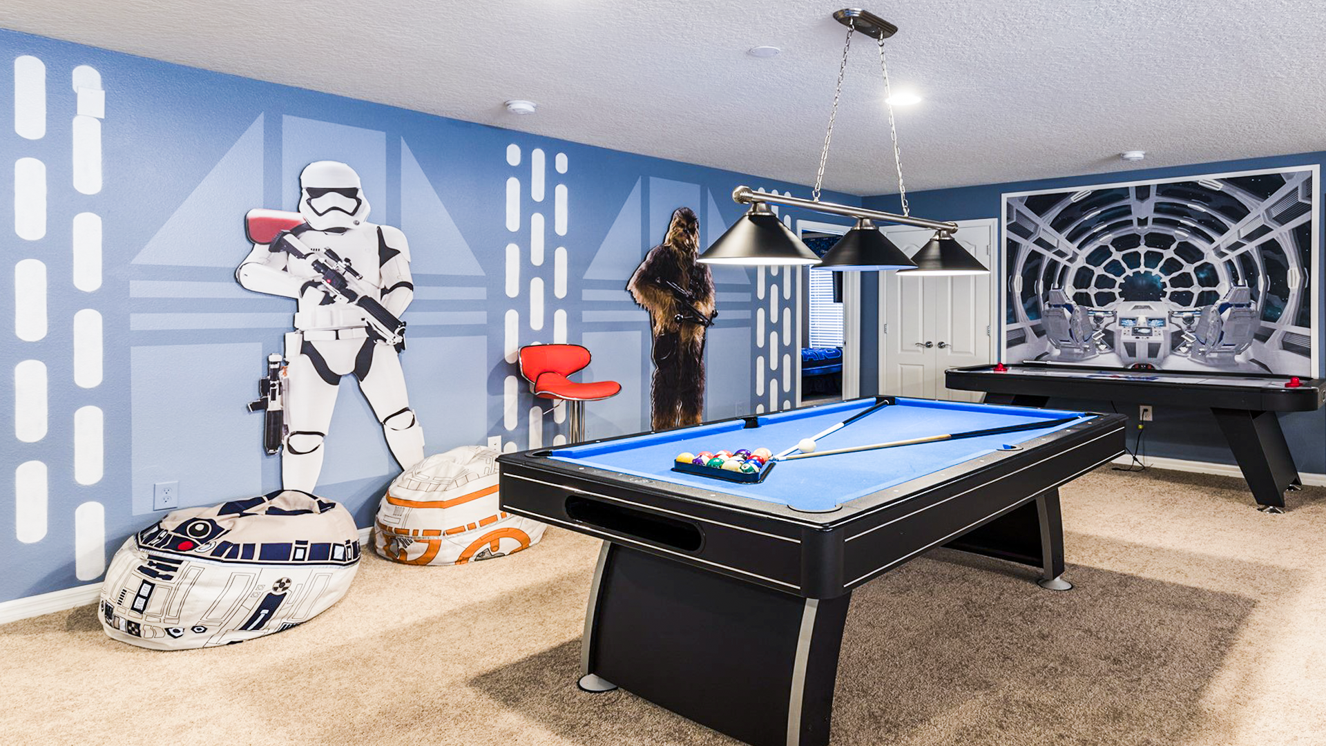 Epic Star Wars game room with pool table, air hockey, themed decor, and bean bag seating.