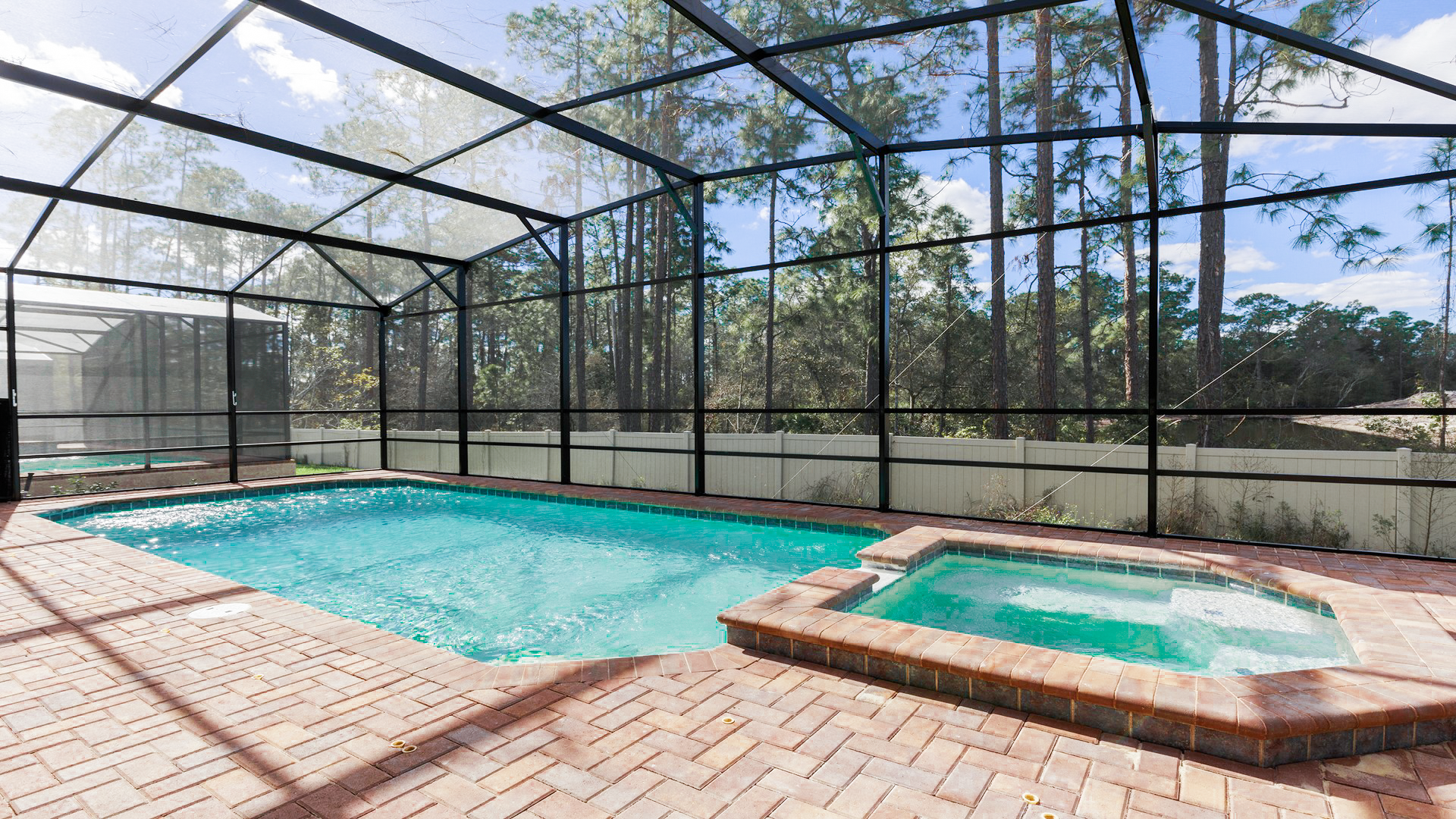 Screened-in private pool and spa with forest views, perfect for relaxation and family fun.
