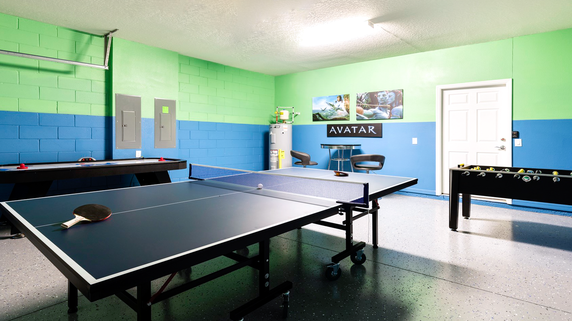Exciting game room with ping pong, foosball, air hockey, and themed wall art.